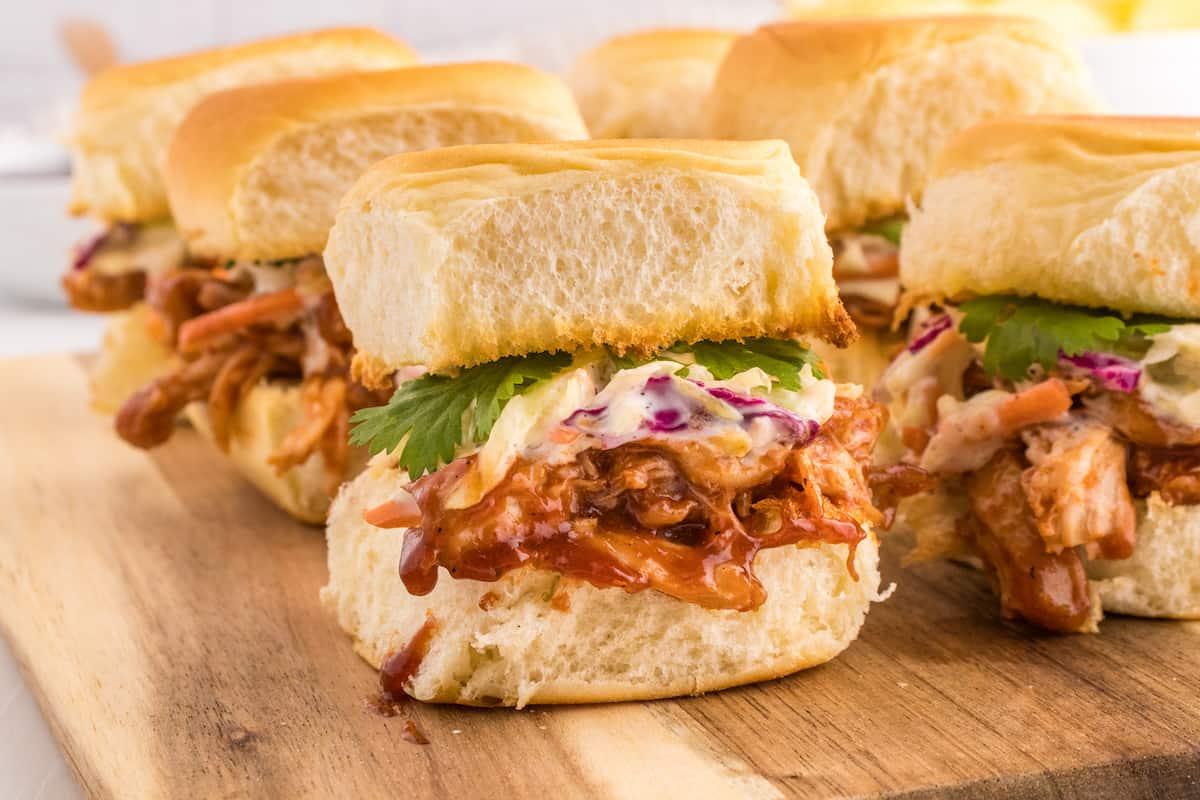 Bbq sliders on a wooden cutting board.