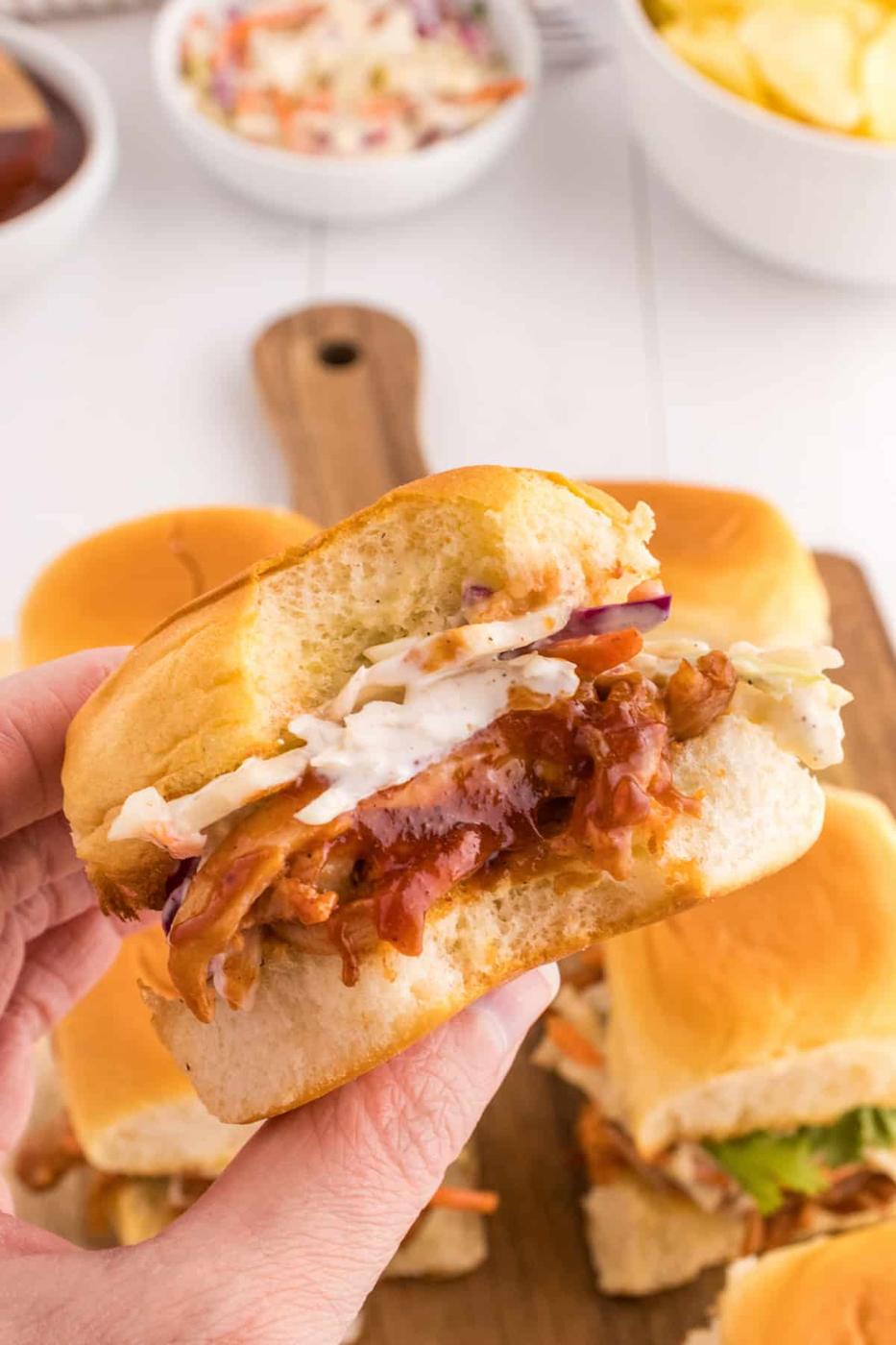 BBQ pulled pork sliders on a cutting board.