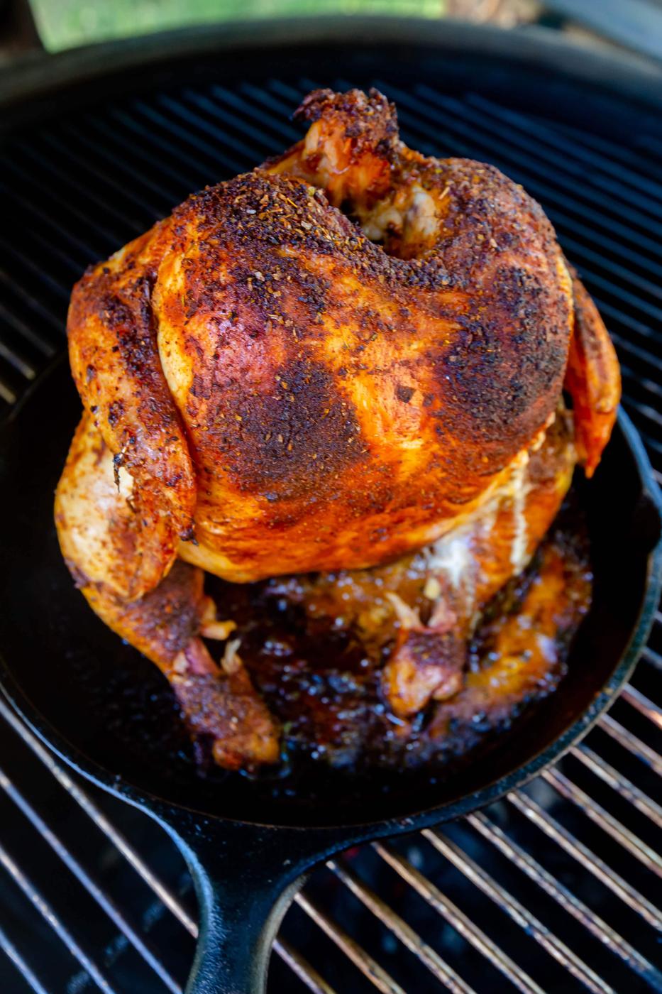 roasted beer can chicken in a cast iron pan on a grill