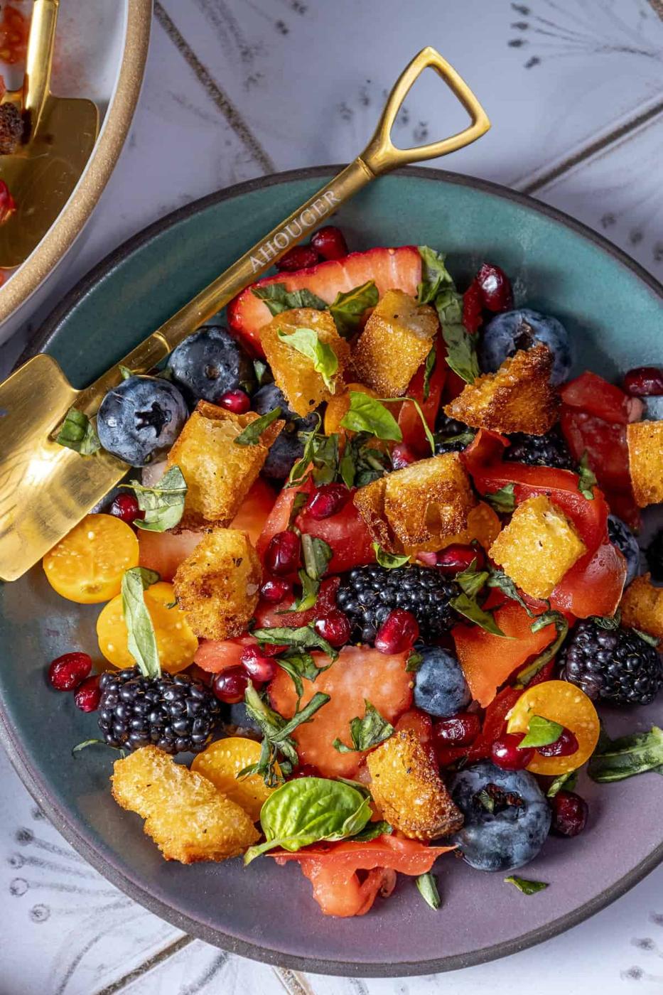 A plate of fruit salad with berries.