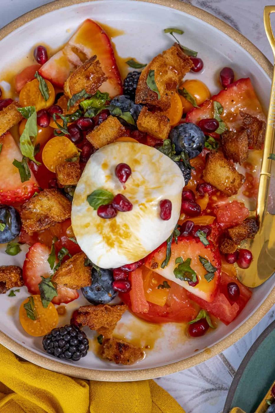 A plate of fruit salad with a poached egg on top.
