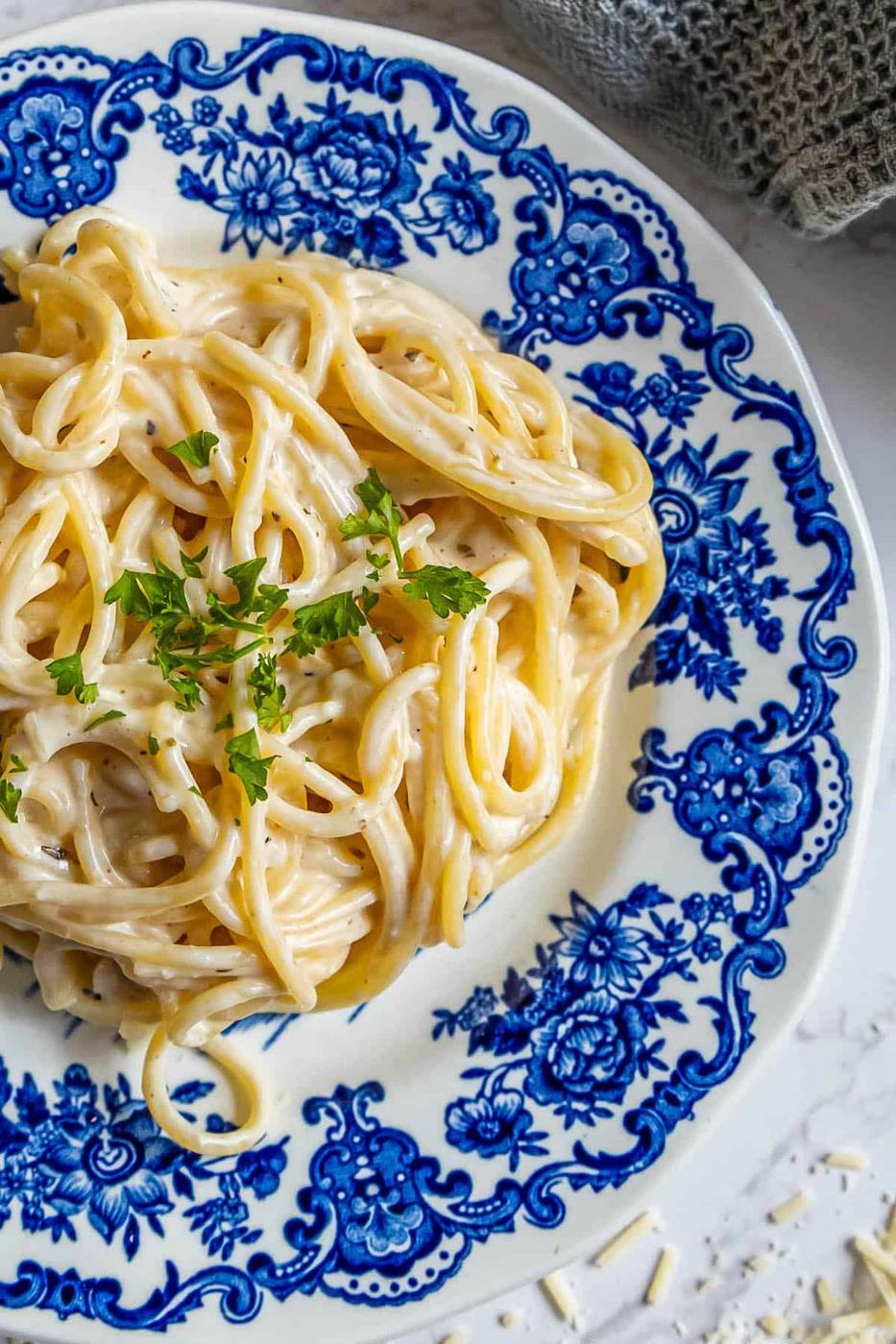 The best plate of pasta smothered in velvety alfredo sauce, topped with freshly grated parmesan cheese and a sprinkle of fragrant parsley.