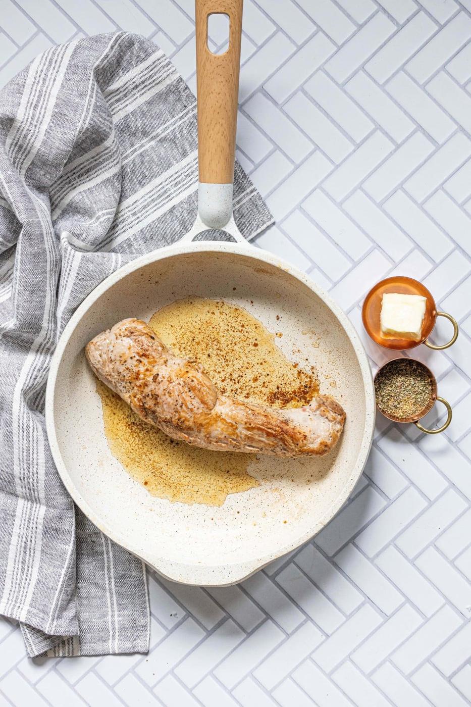 pan with browned pork tenderloin in it