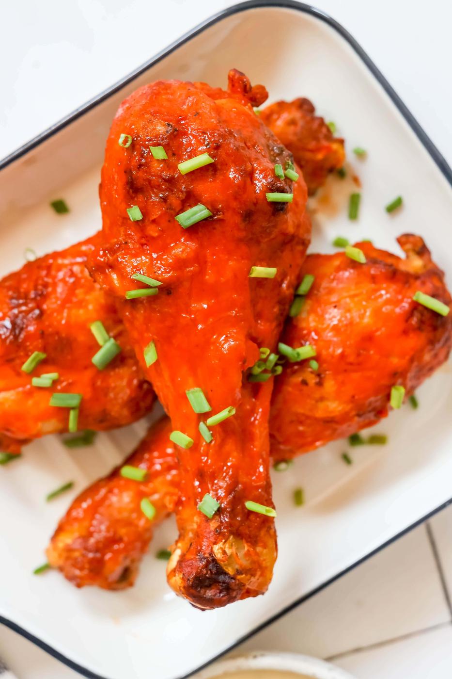 chicken drumsticks with red buffalo sauce on them