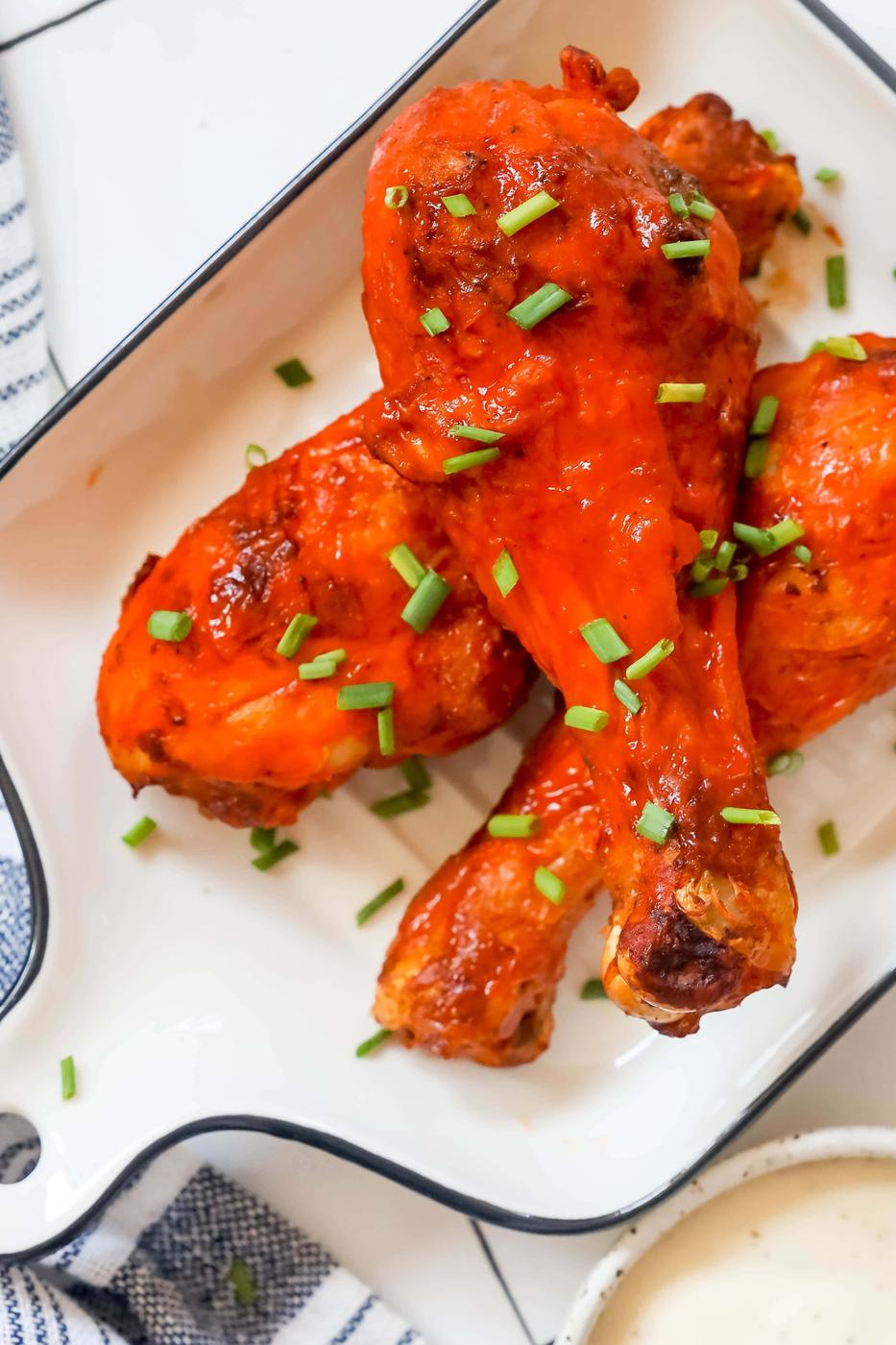 chicken drumsticks with red buffalo sauce on them
