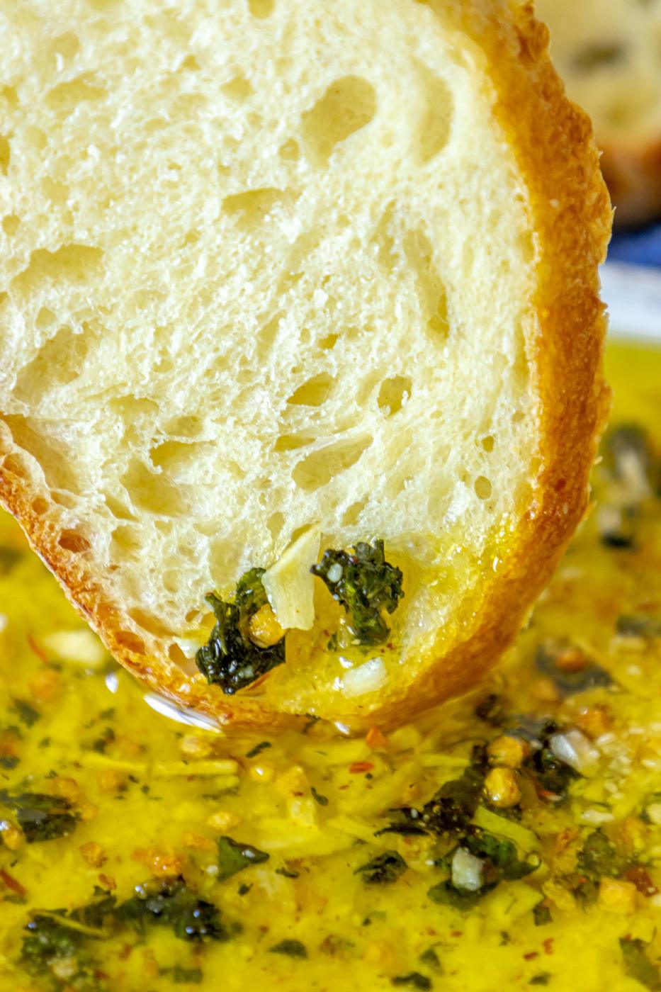 a slice of bread dipped in olive oil bread dip