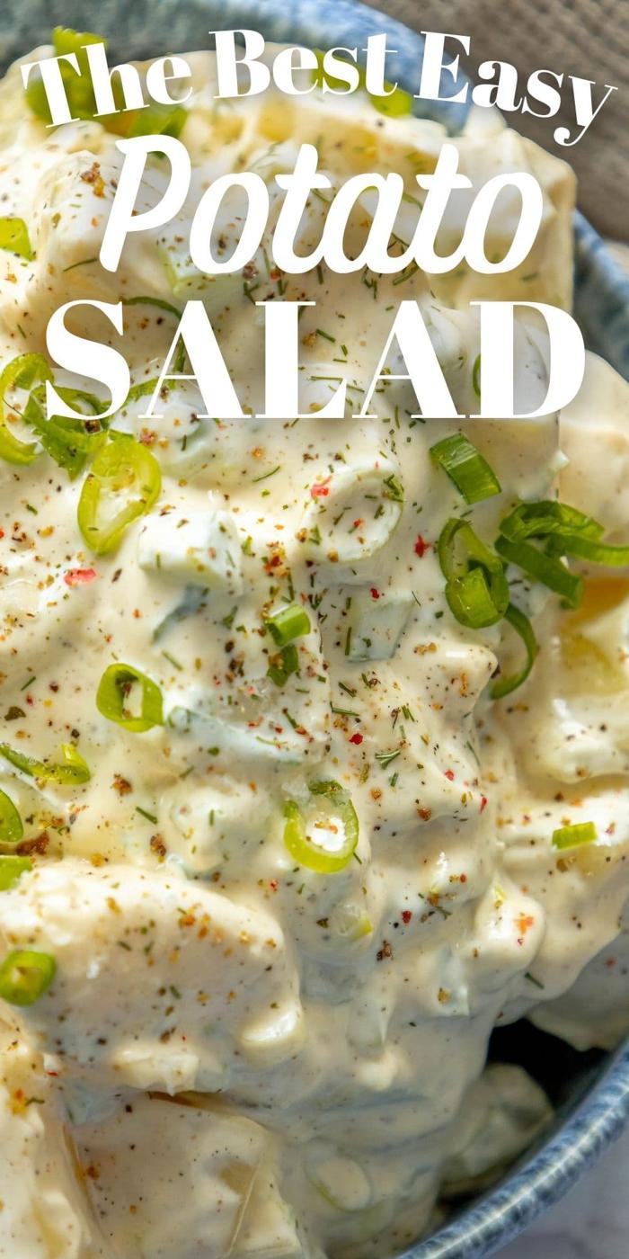 picture of creamy potato salad with green onions and cracked pepper in a blue bowl
