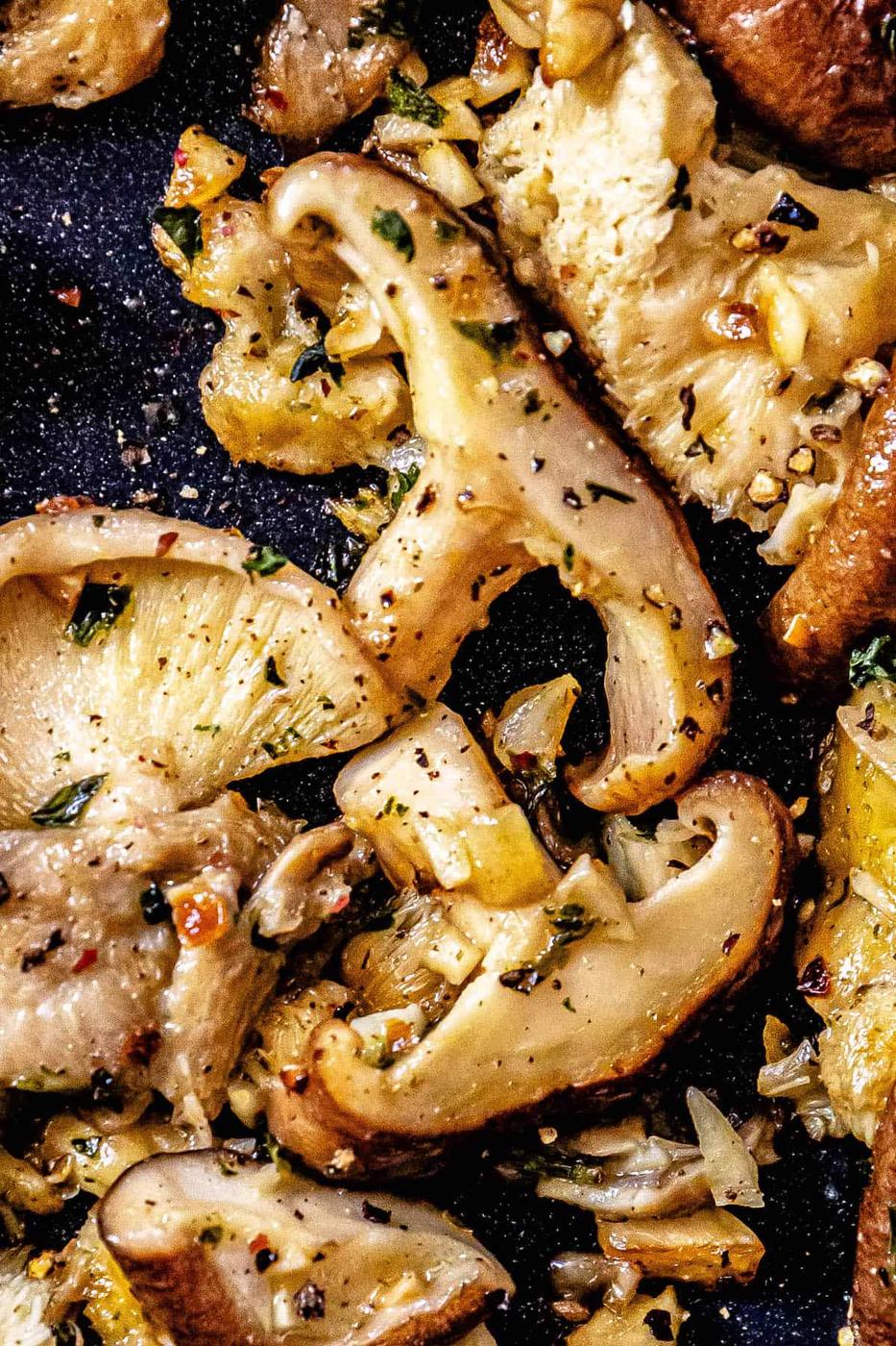 A pan with mushrooms and herbs on it.
