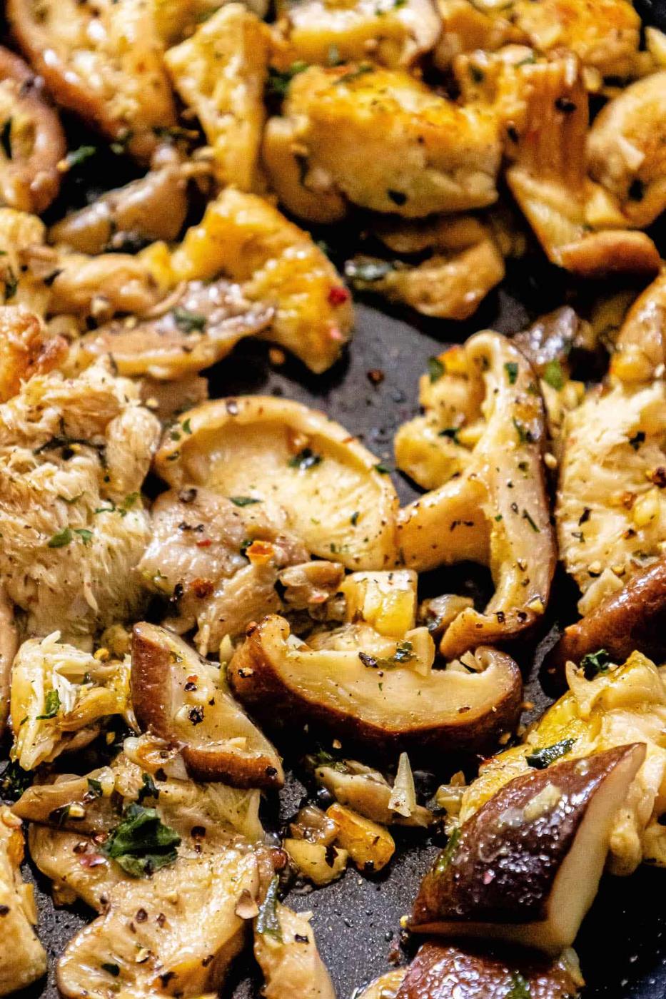 Chicken and mushrooms in a skillet.
