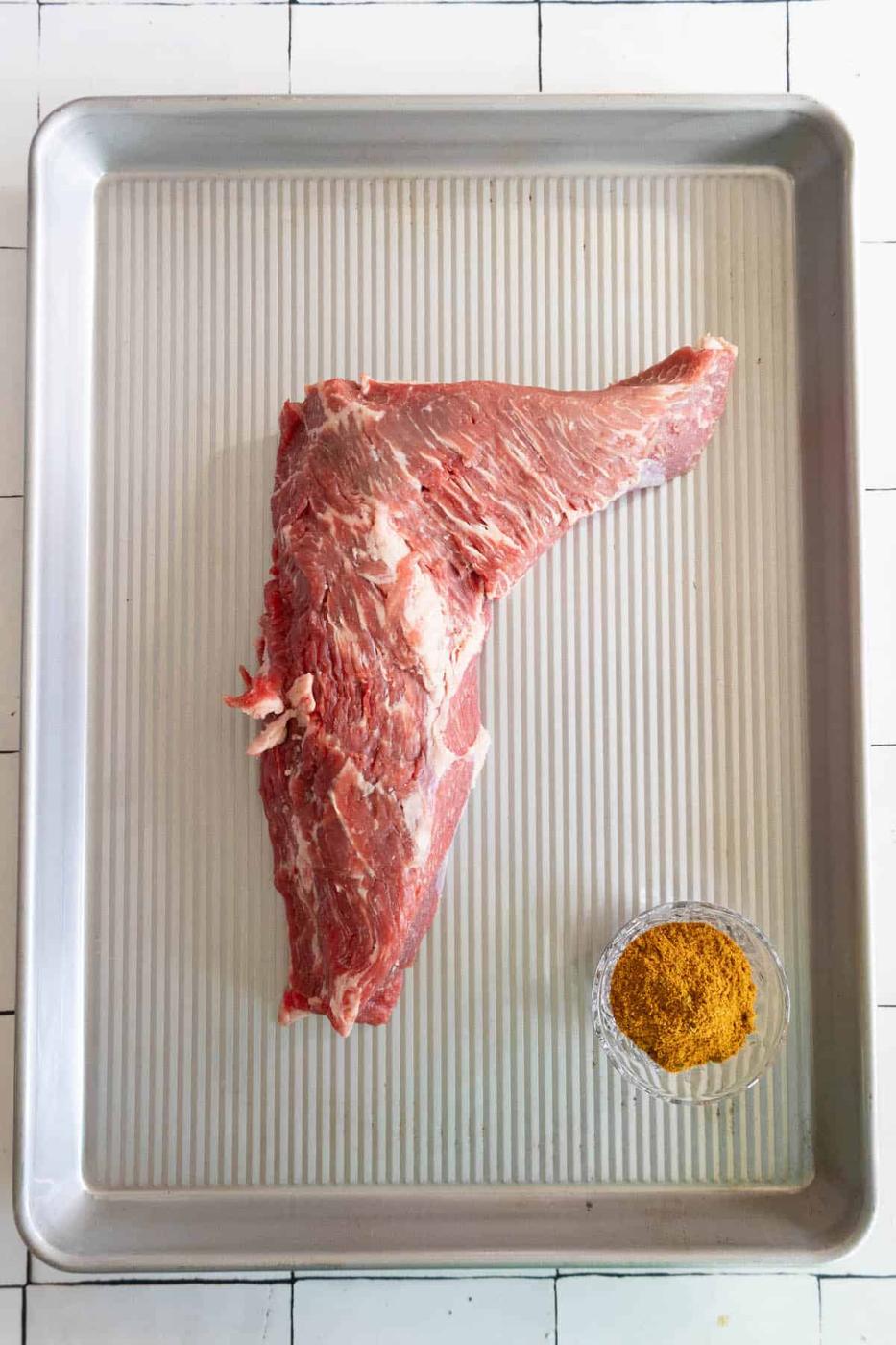 A reverse seared tri-tip steak on a baking sheet.
