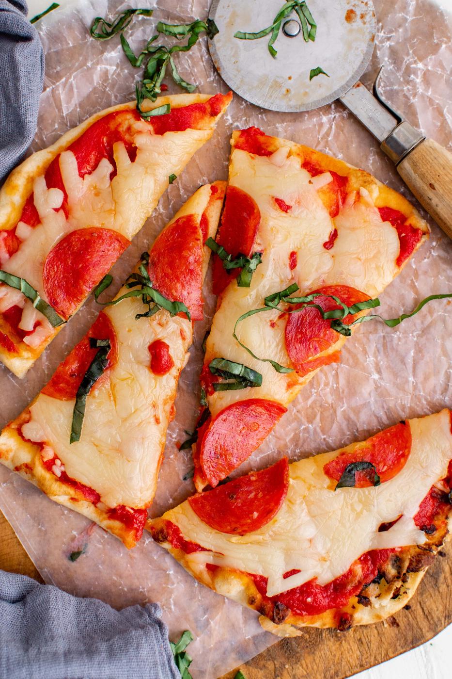 A slice of keto pepperoni pizza on a cutting board.