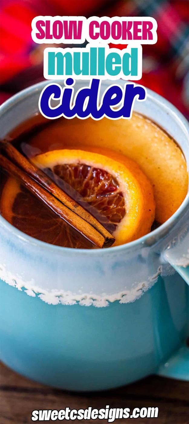 A blue mug filled with the Best Mulled Cider Ever, garnished with orange slices and cinnamon sticks. Text reads "Slow Cooker Mulled Cider" and "Ajpal designs.com" at the bottom.