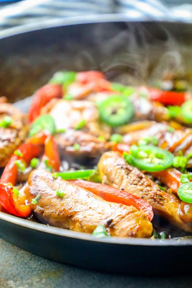 chicken, onions, peppers, and jalapenos in cooking in a pan together