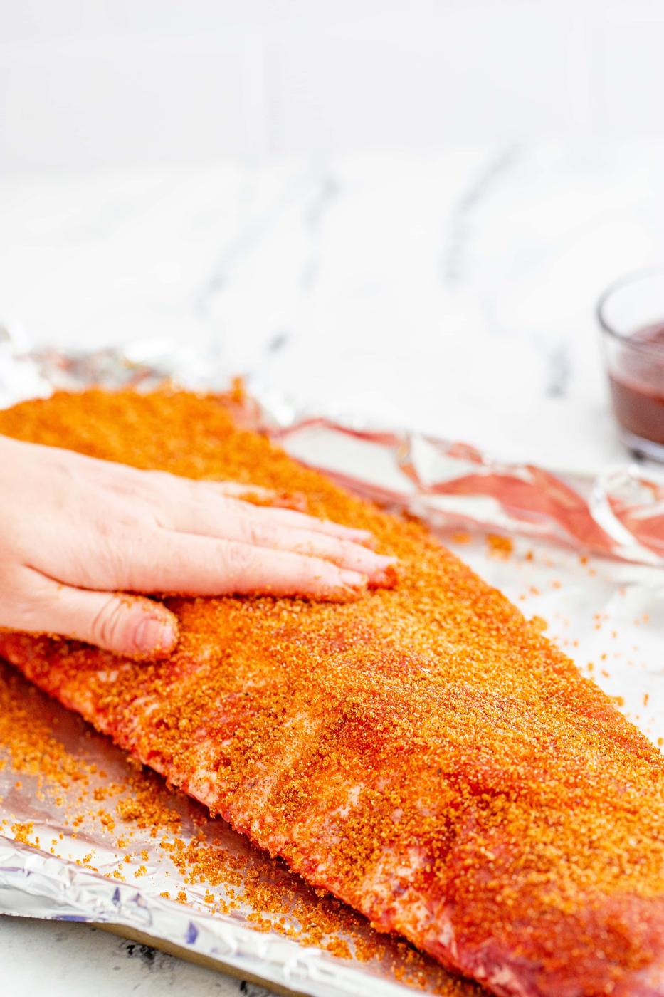 hand rubbing rib rub into raw ribs