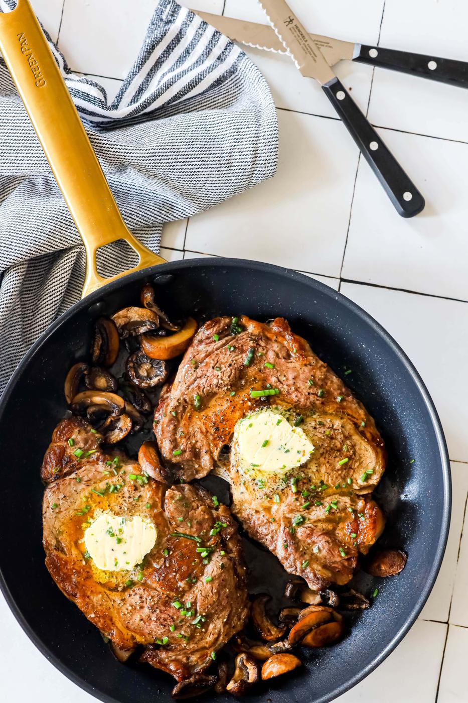 Pork chops cooked in skillet with mushrooms.