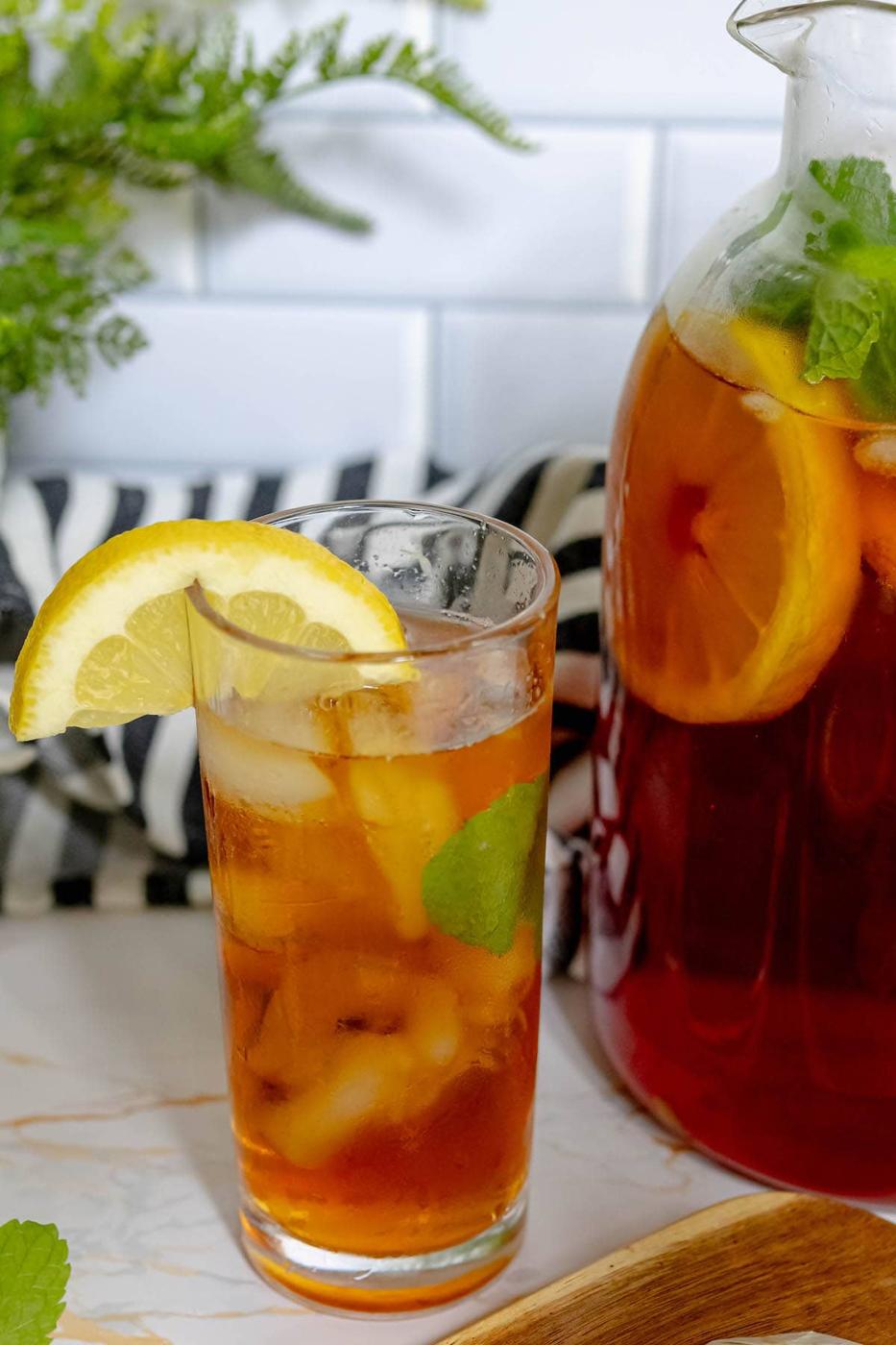 tea in a tall glass next to a pitcher of sweet tea