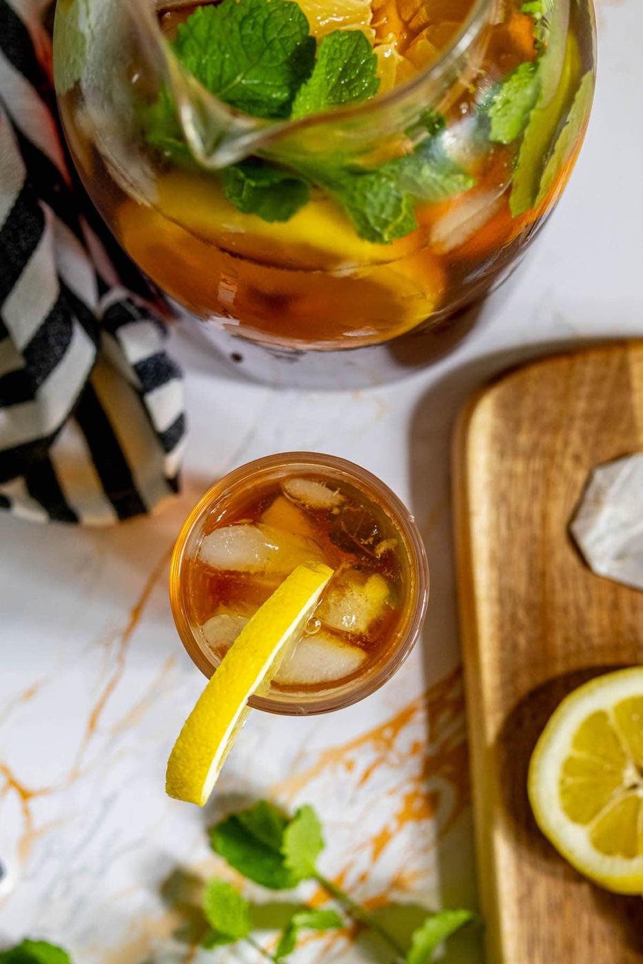 tea in a tall glass next to a pitcher of sweet tea