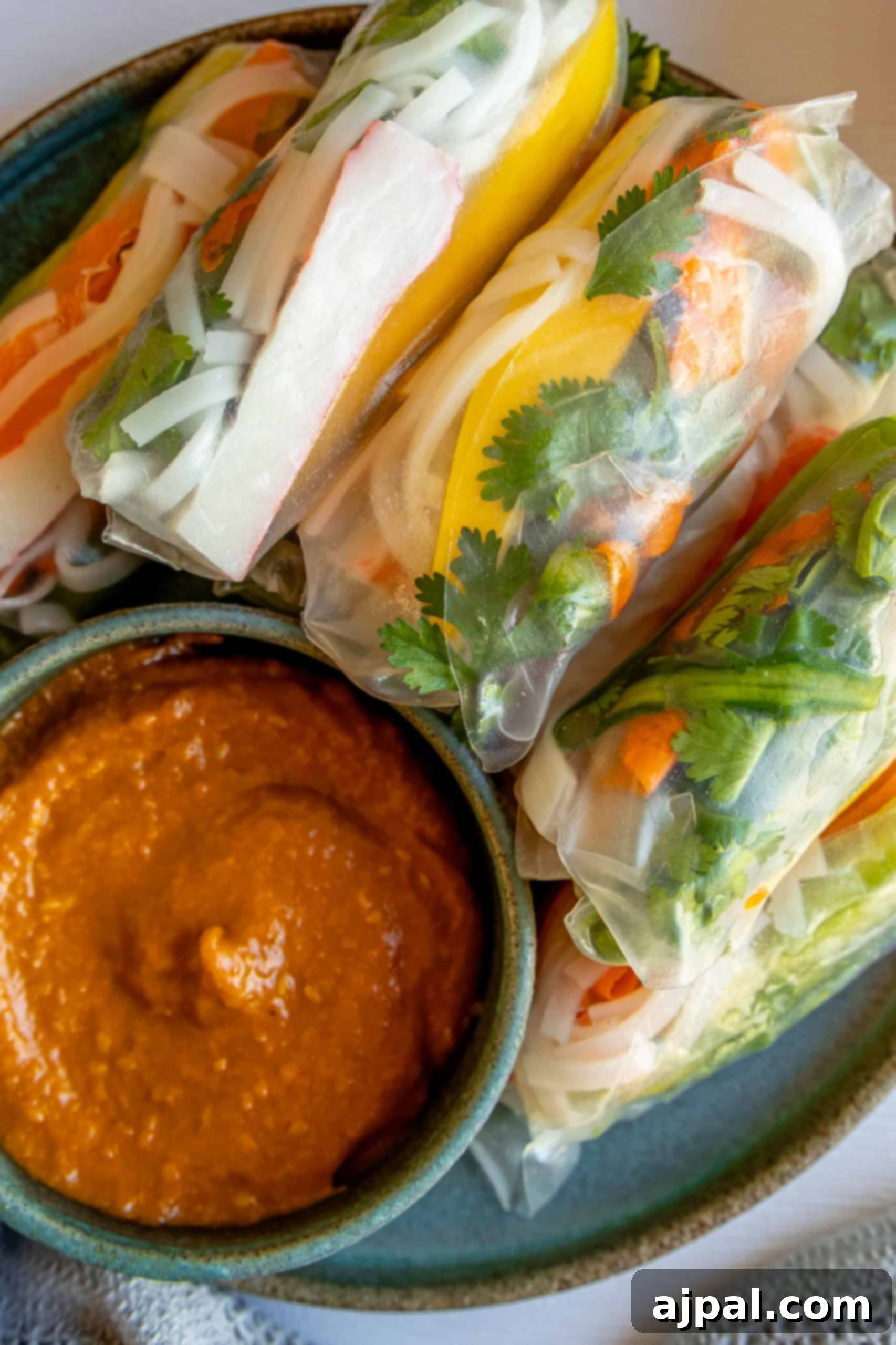 Crab spring rolls served on a plate with dipping sauce.