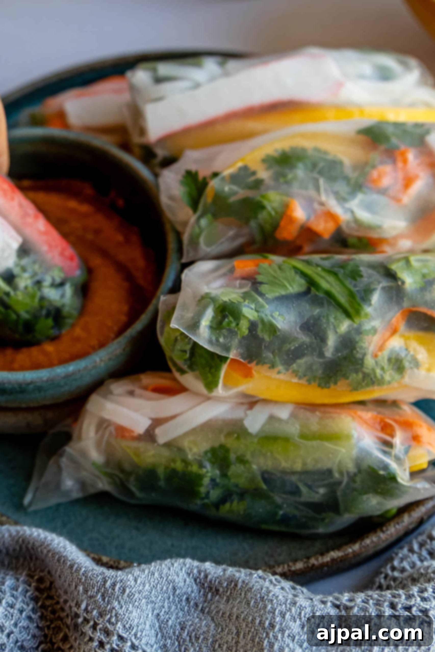 Crab spring rolls on a plate with dipping sauce.