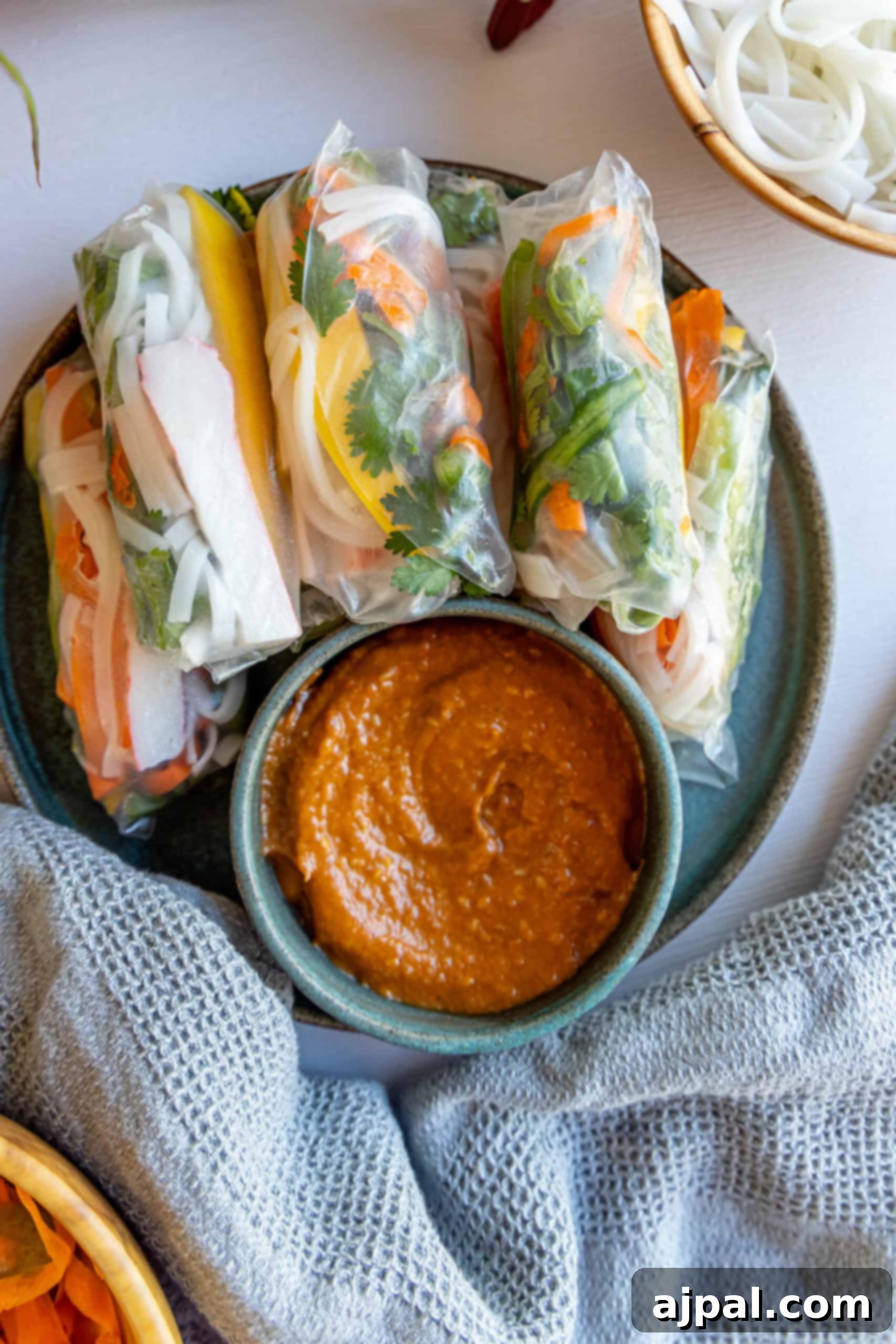 Vietnamese crab spring rolls on a plate with dipping sauce.