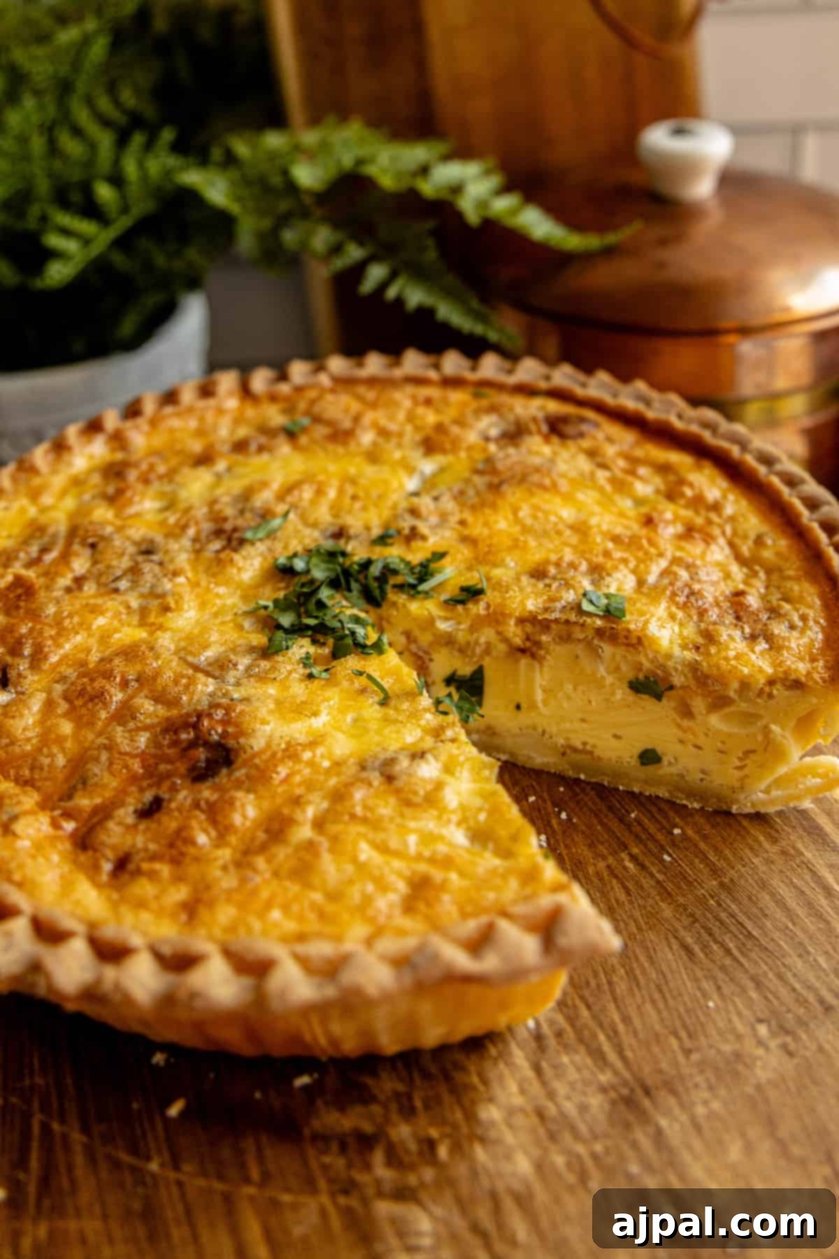 A perfectly baked bacon and cheese quiche with a slice removed, revealing its delicious layers.