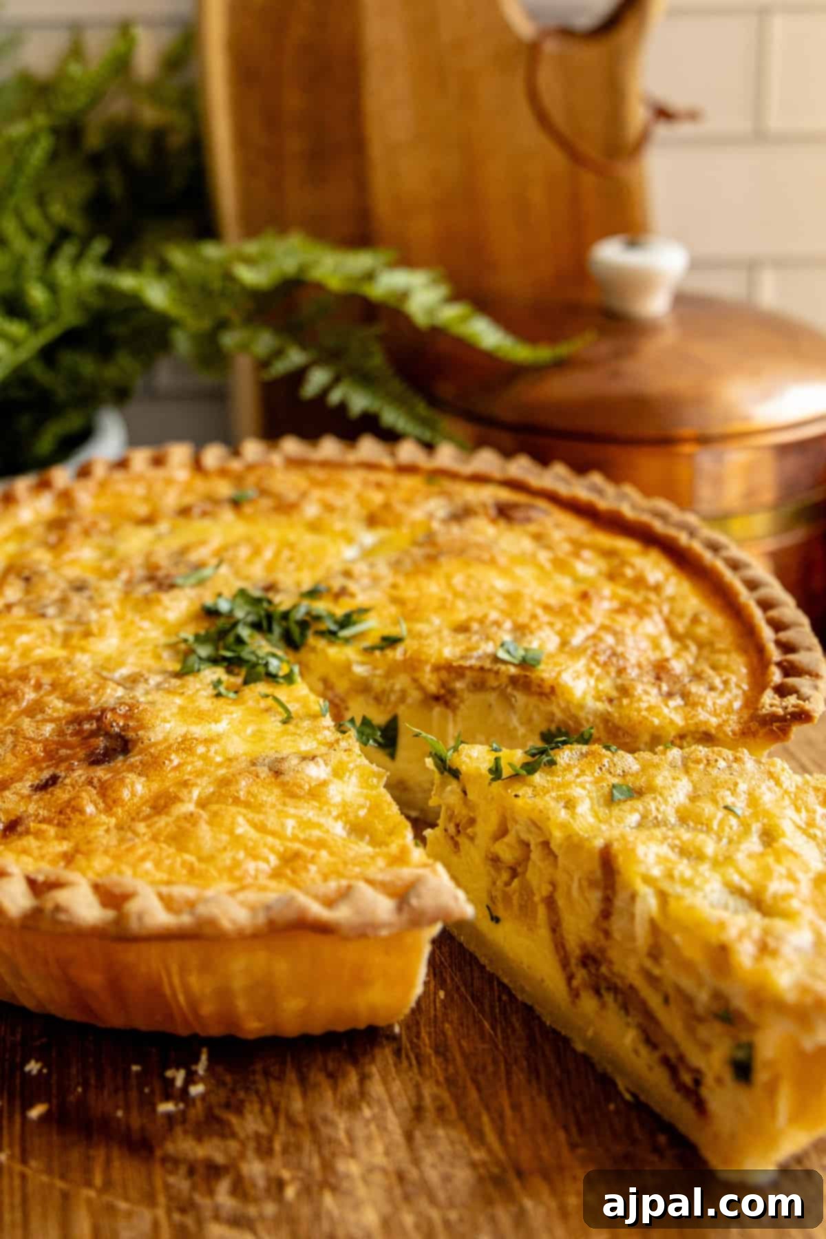 A freshly baked quiche with a golden brown crust, displaying a missing slice ready for serving.
