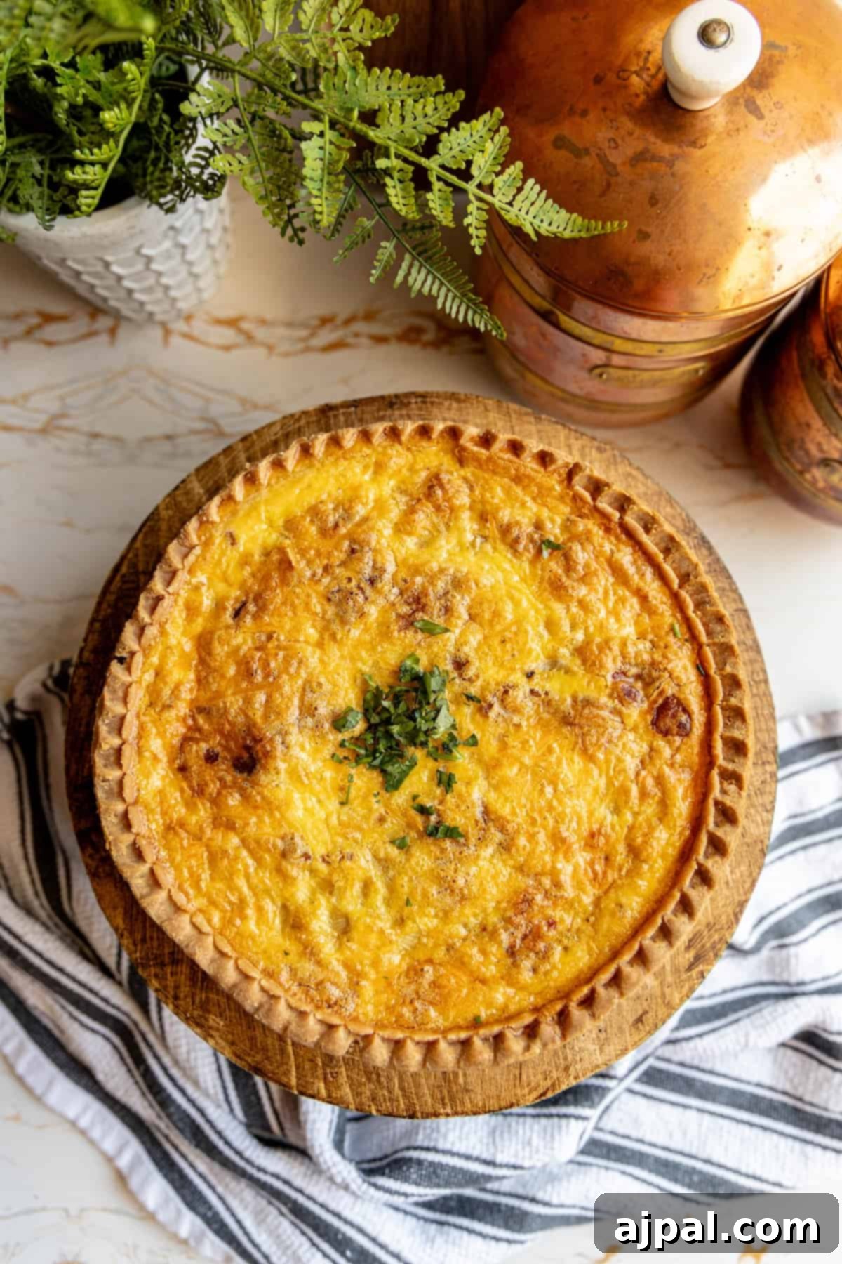 A freshly baked bacon cheese quiche, perfectly golden, served on a rustic wooden plate.