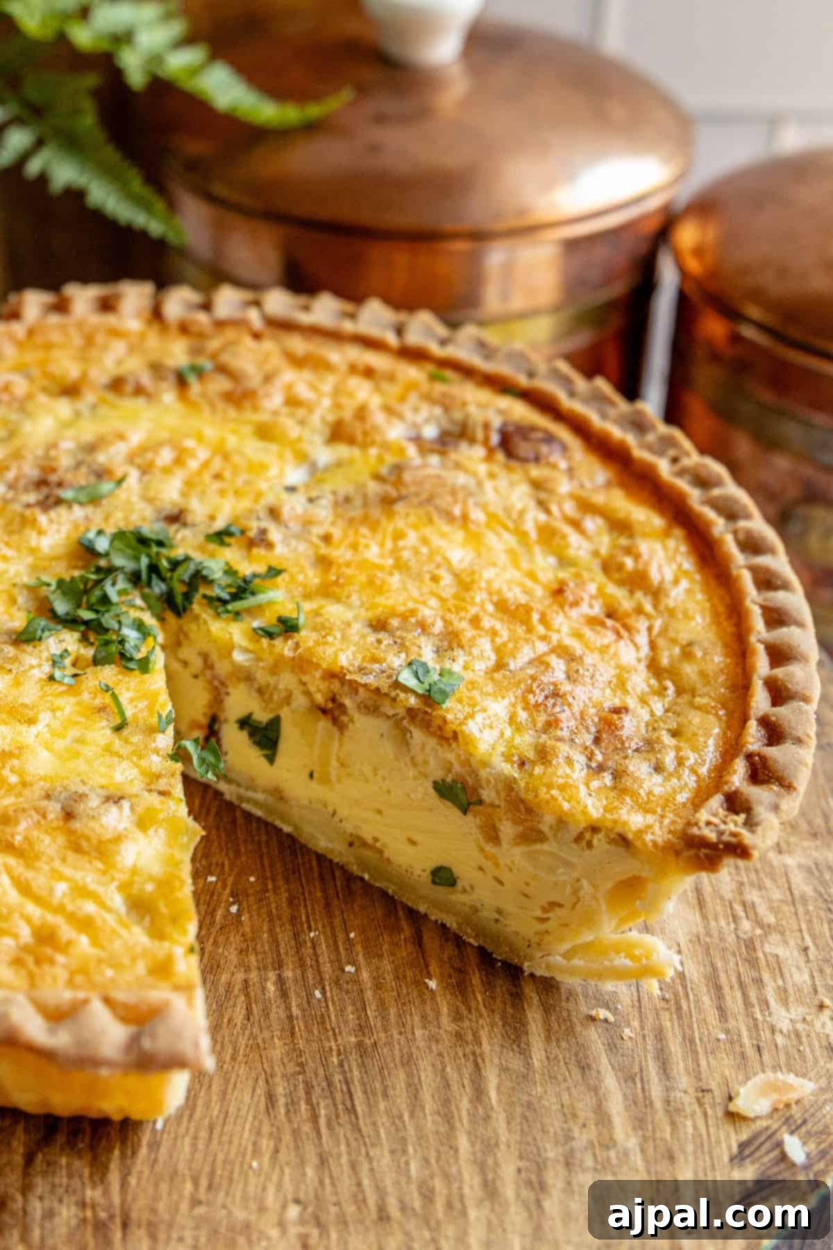 A freshly baked bacon quiche with a single slice removed, showcasing the golden crust and creamy filling.