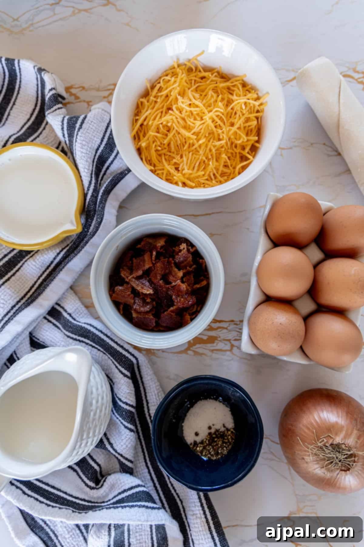 A table laden with fresh ingredients for bacon cheese quiche, including bacon, cheese, eggs, and onions.