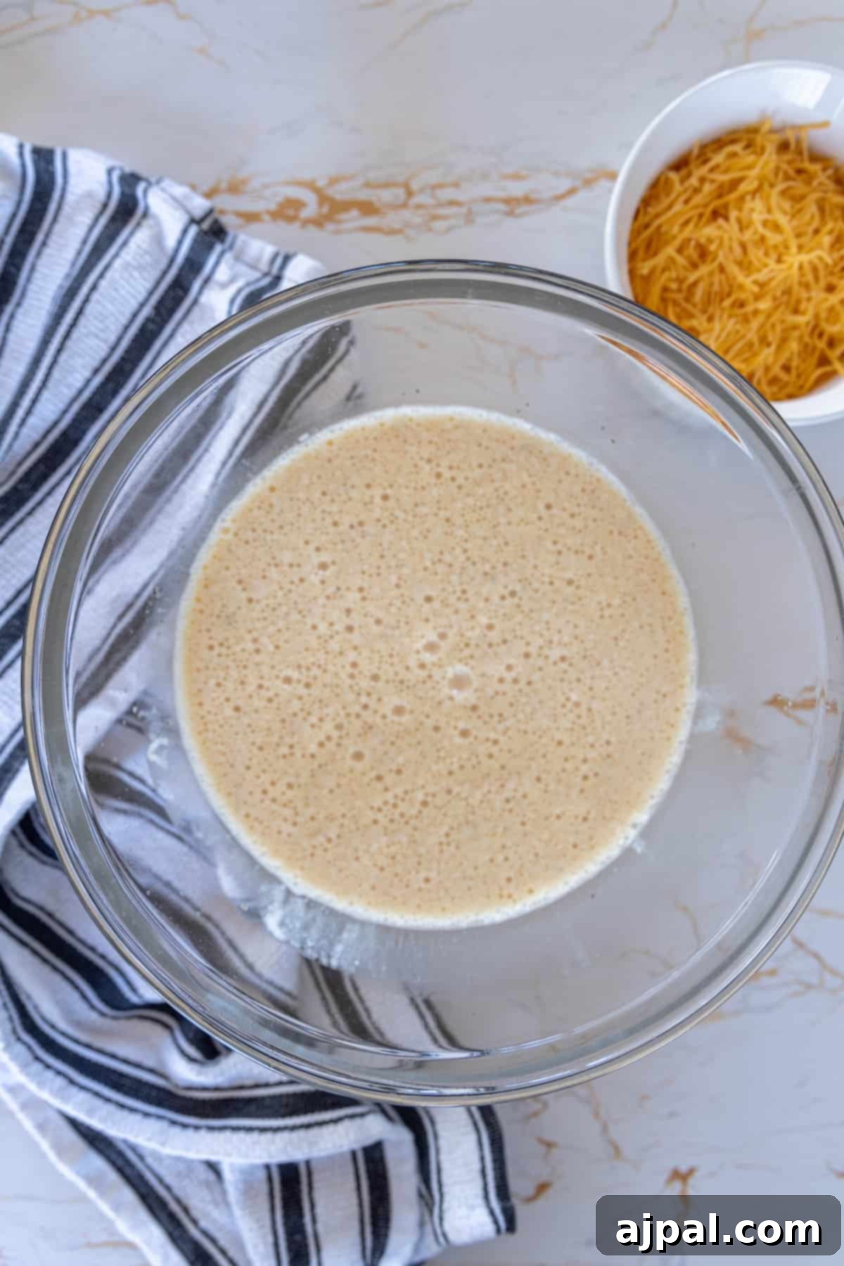A bowl containing the creamy egg and milk mixture, ready for the quiche filling.