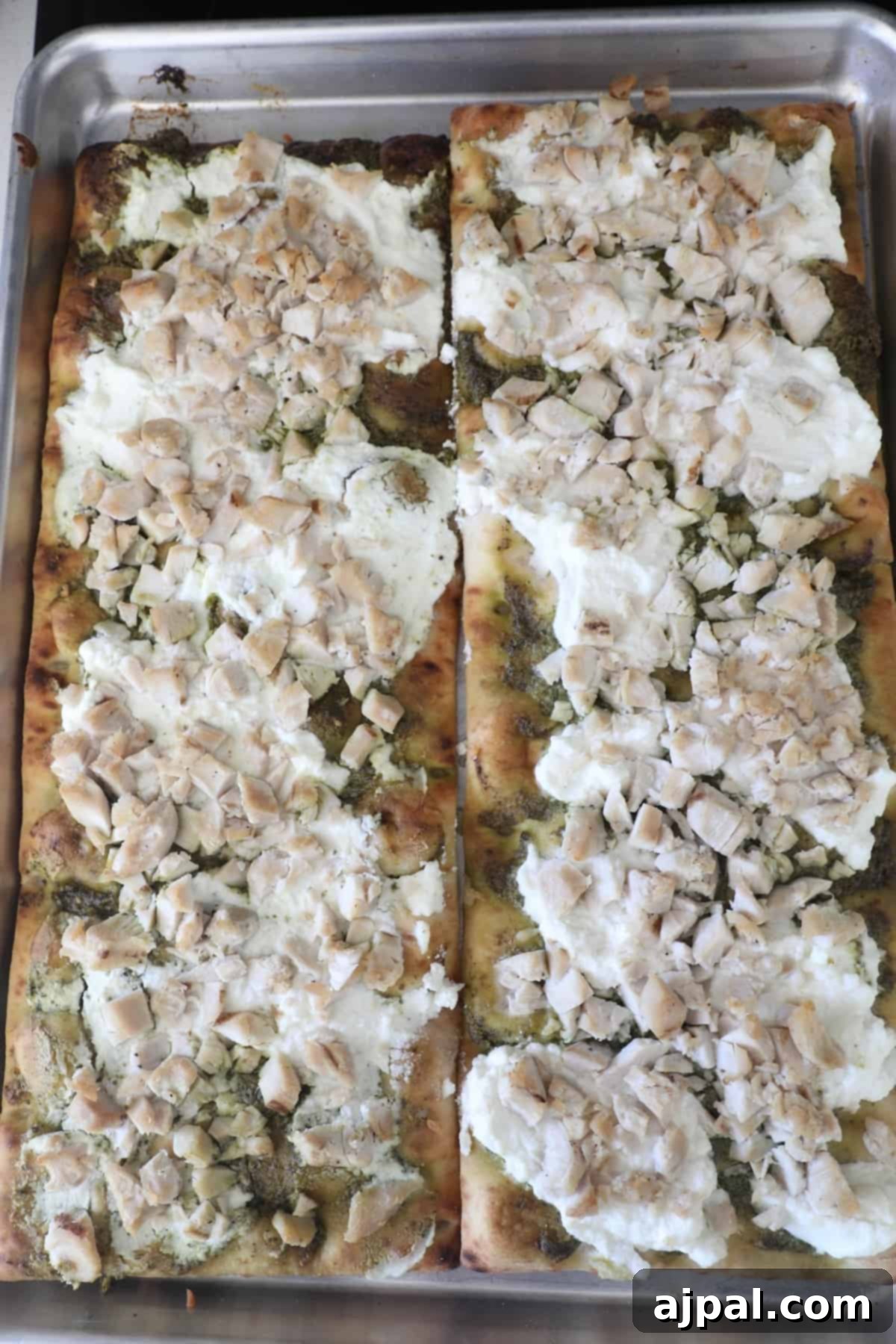 Artisan Pesto Chicken Flatbread 8 A flatbread pizza topped with thinly sliced mushrooms and creamy white cheese, showcasing a variation of toppings.