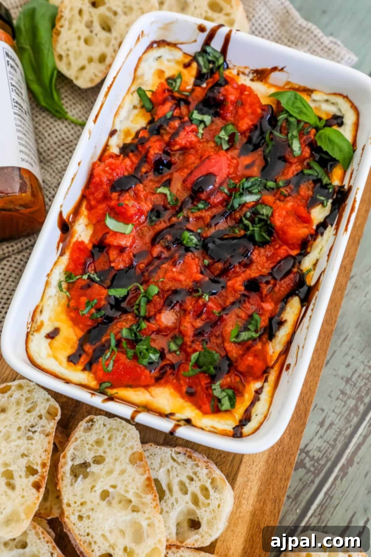 A beautifully presented dish of vibrant tomato and basil dip, accompanied by slices of toasted bread on a rustic cutting board, ready for an enticing appetizer.
