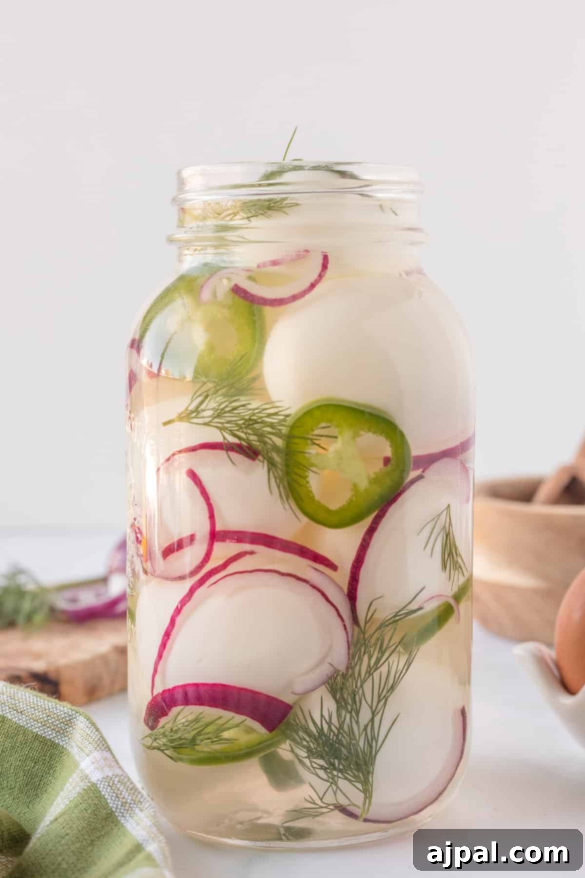 A mason jar overflowing with vibrant spicy pickled eggs, a truly inviting snack.