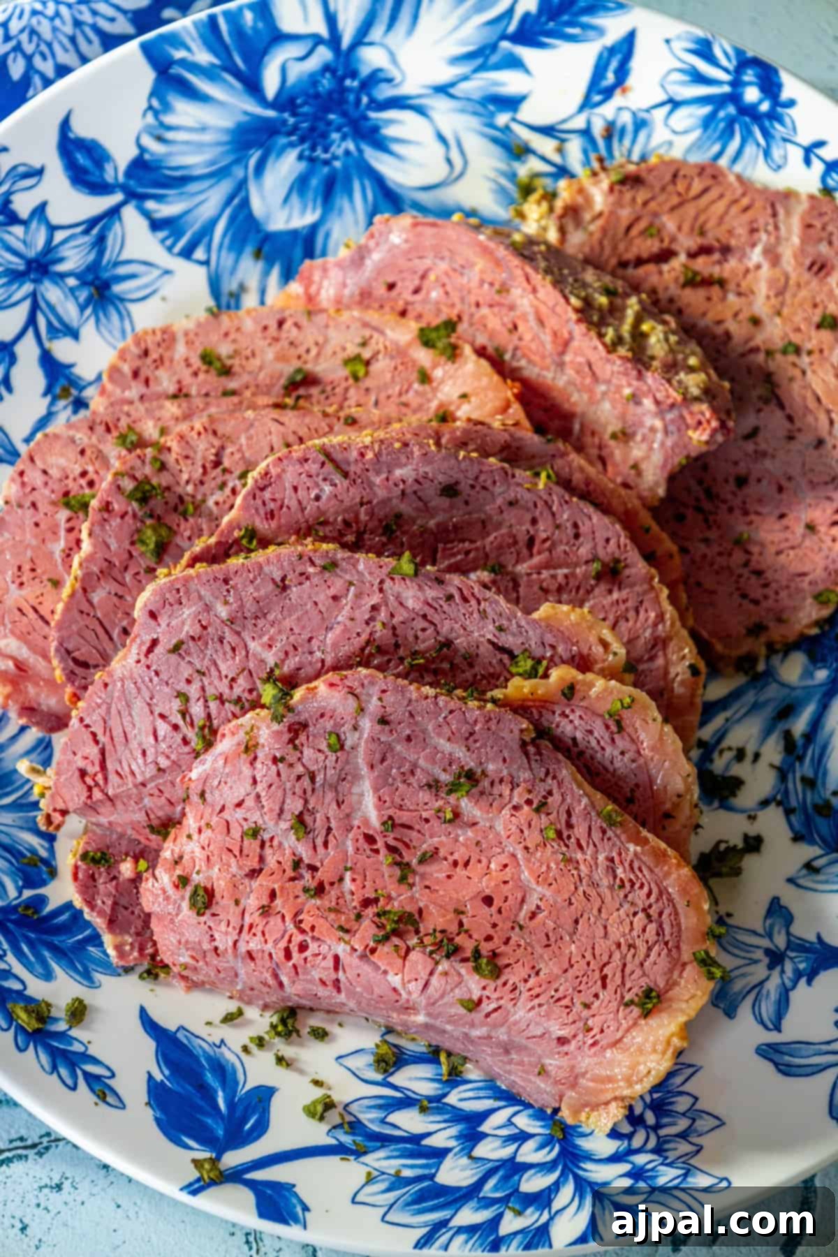 Perfectly Roasted Corned Beef 3 A serving of succulent roasted corned beef, perfectly glazed and ready to be enjoyed, on a blue and white floral patterned plate.