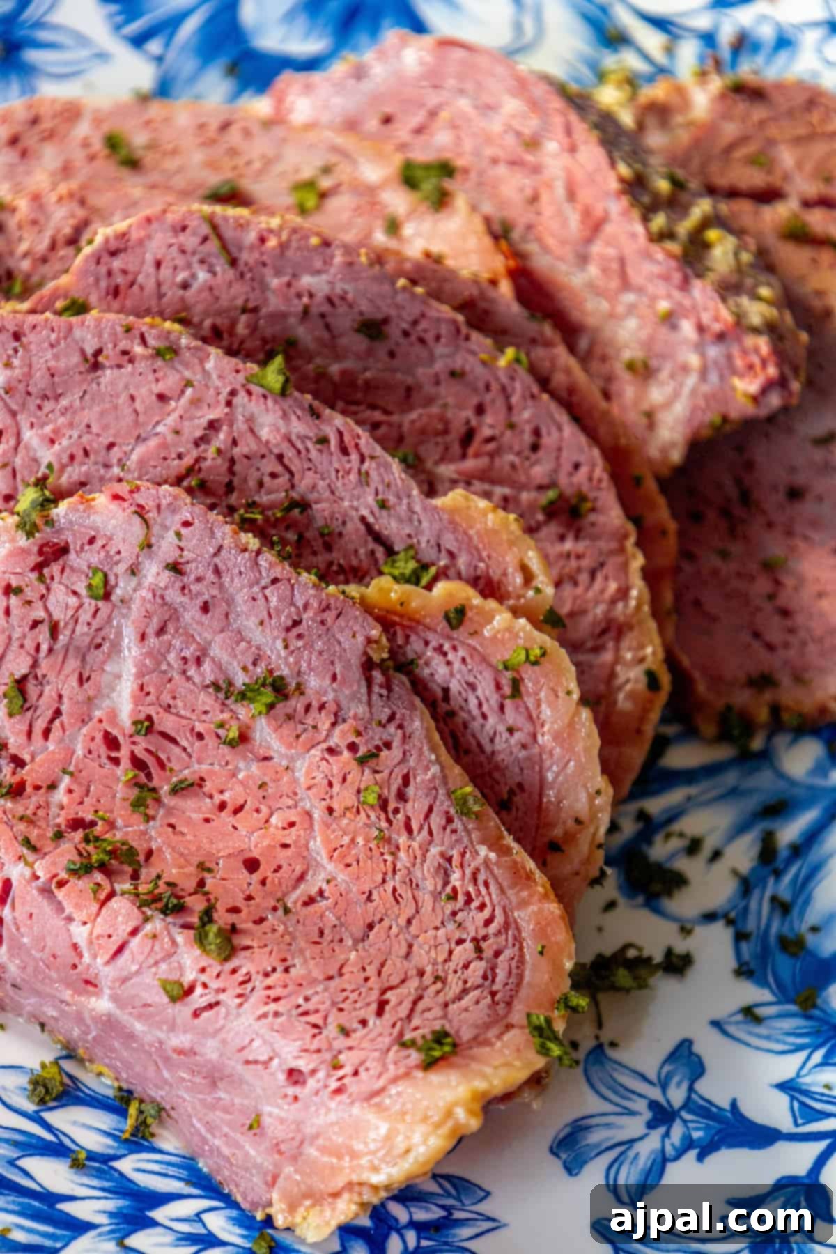 Perfectly Roasted Corned Beef 4 Perfectly sliced roasted corned beef, showcasing its tender texture and delicious glaze, artfully arranged on a blue plate.