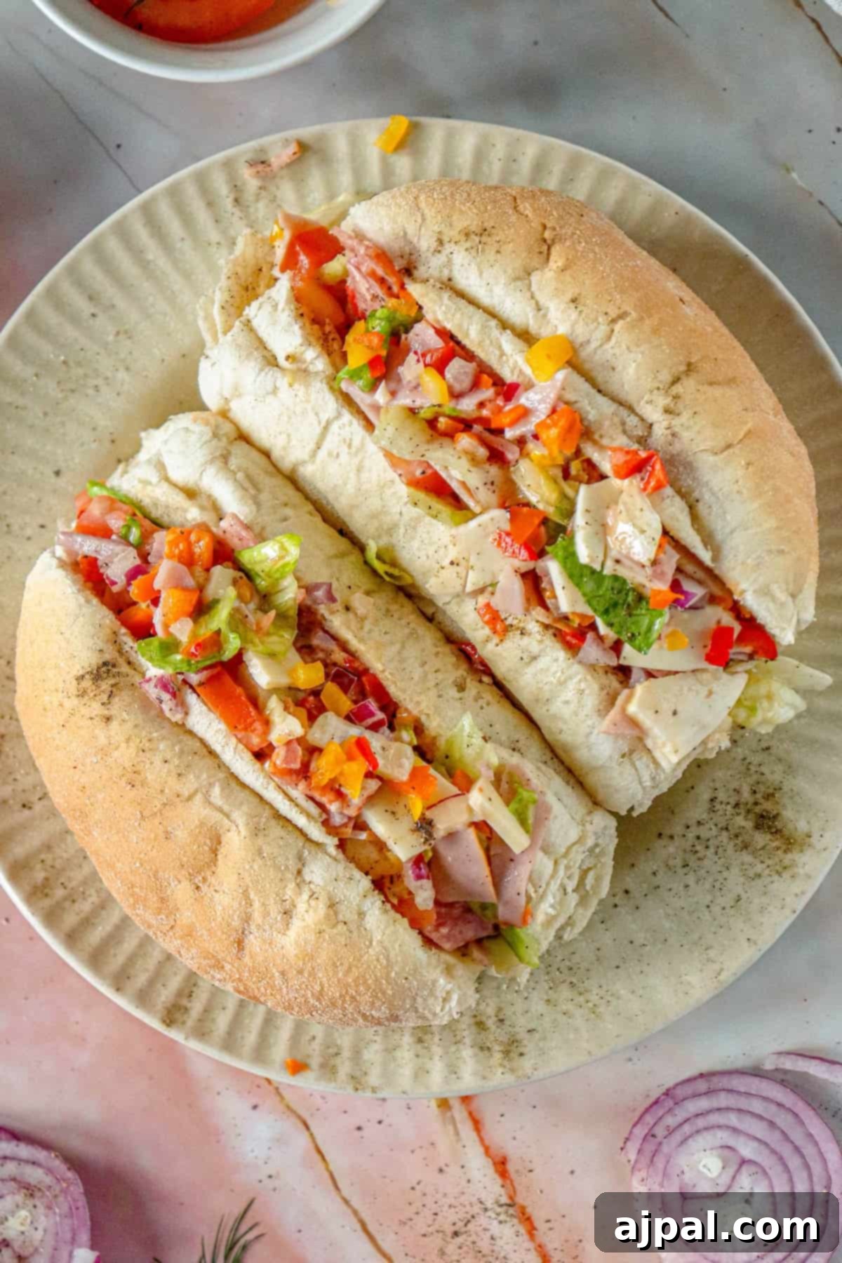 A vibrant plate featuring two meticulously prepared Chopped Italian Sandwiches.