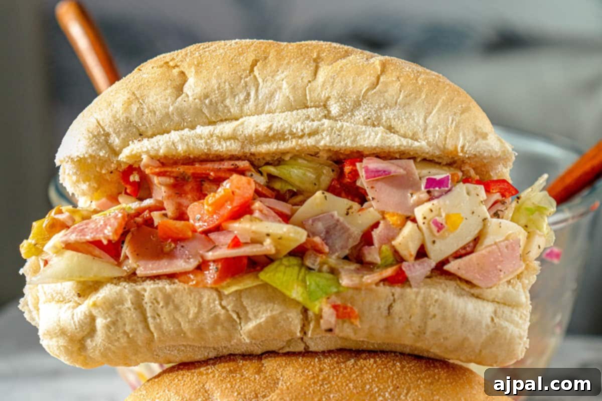 A generously filled Chopped Italian Sandwich, with a delicious mix of ham and a vibrant salad, neatly presented.