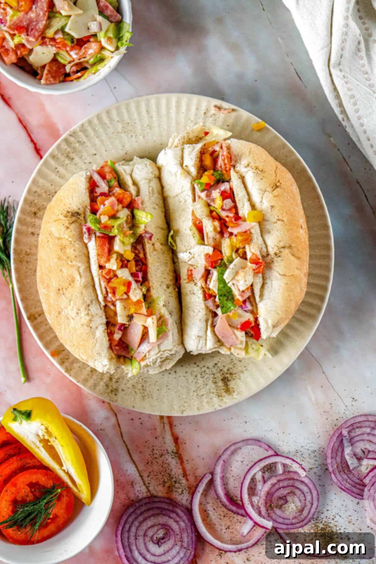 A beautifully presented Chopped Italian Sandwich on a plate, accompanied by a fresh side salad.
