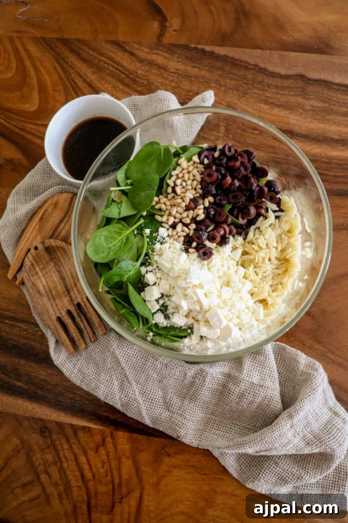 Greek Spinach Feta Orzo Salad 6 A bowl filled with spinach and cheese.