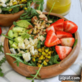 Two wooden bowls with a strawberry crunch salad.