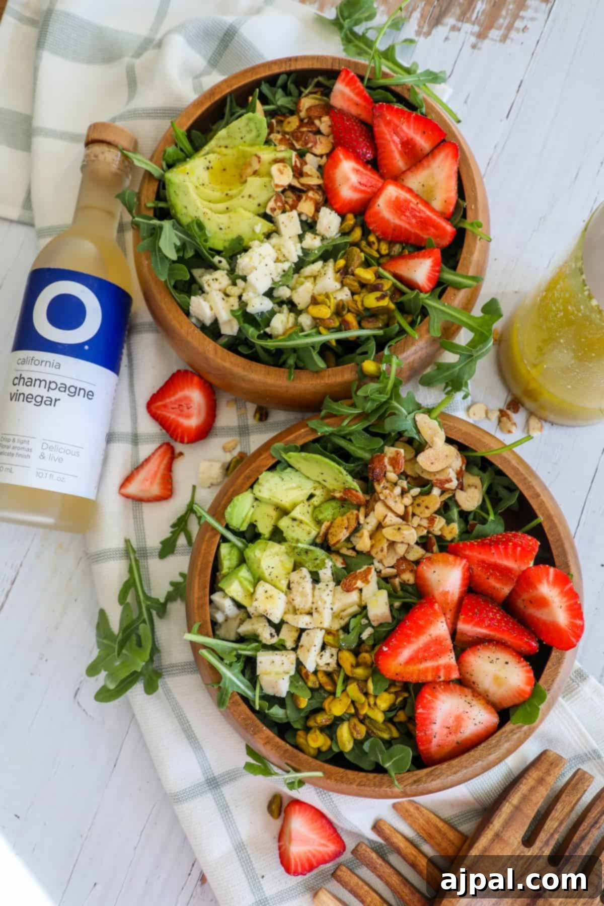 A single bowl brimming with Strawberry Crunch Salad, highlighting the fresh strawberries, mixed greens, and crunchy nuts, with a light dressing.