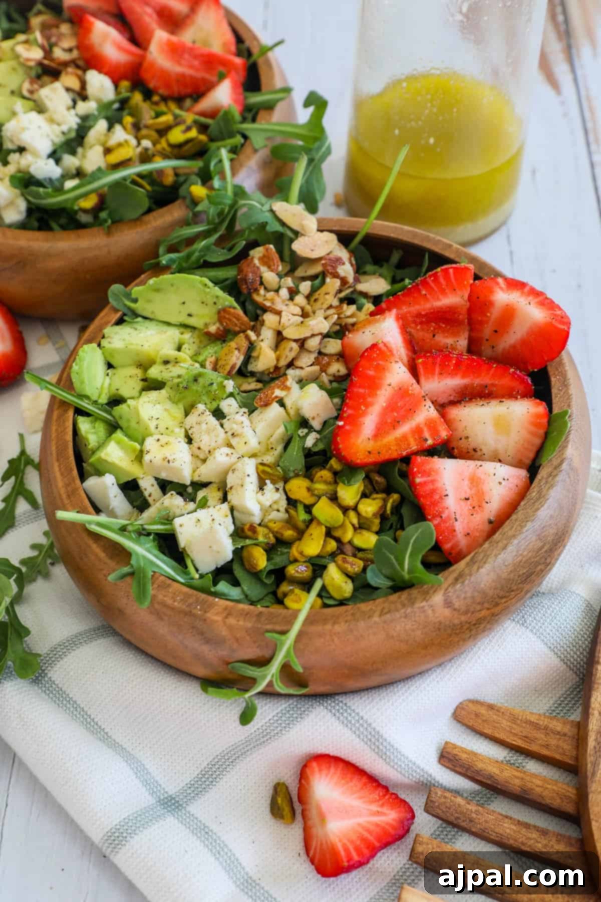 A beautifully presented Strawberry Crunch Salad, featuring succulent strawberries and an assortment of nuts, dressed and ready to eat.