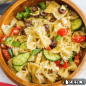Zesty Greek Pasta Salad 7 A bowl of Greek pasta salad with tomatoes, cucumbers, and olives.