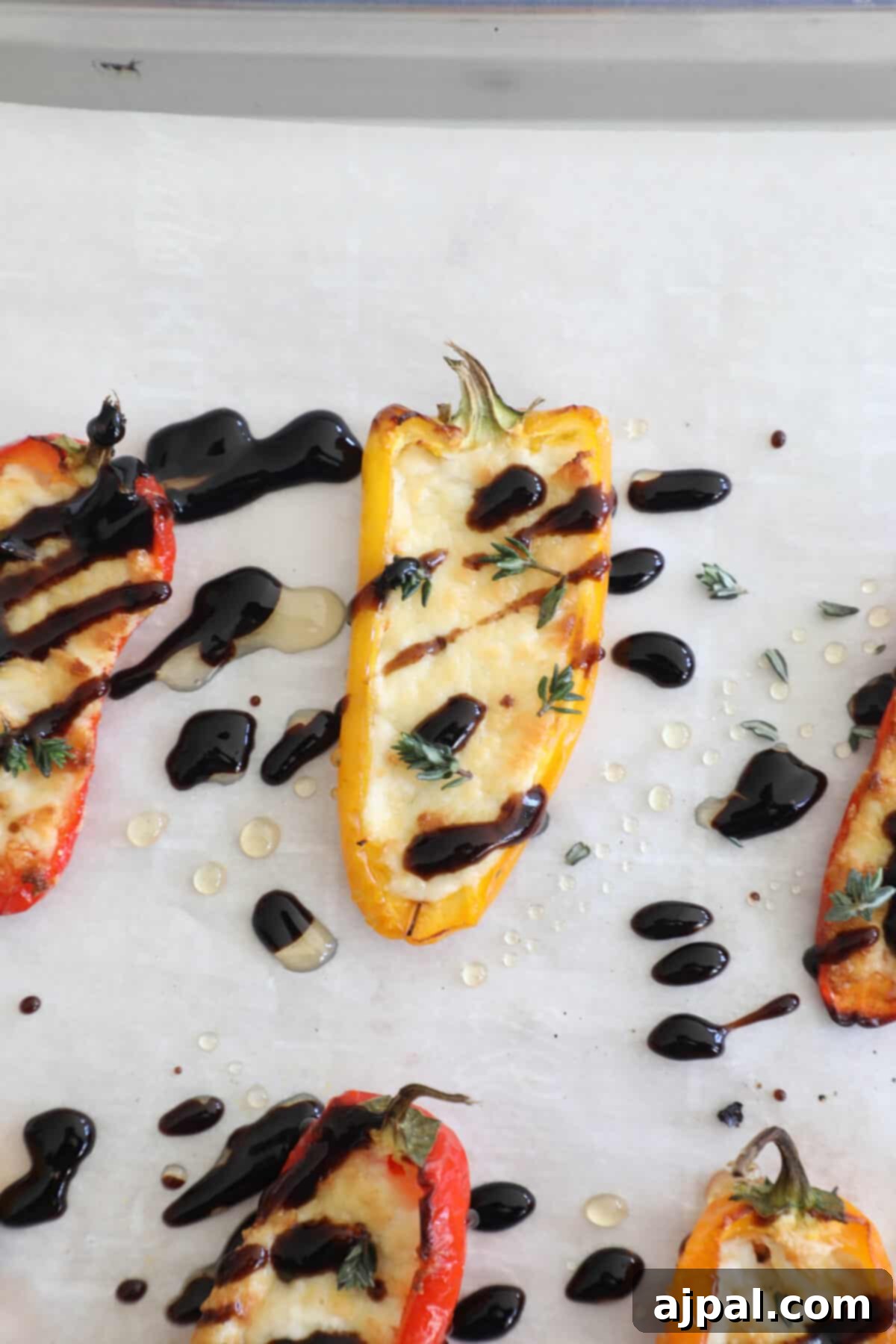 Goat Cheese Stuffed Peppers 9 A baking sheet showcasing freshly baked goat cheese stuffed peppers, glistening with a drizzle of balsamic glaze, ready to be plated.
