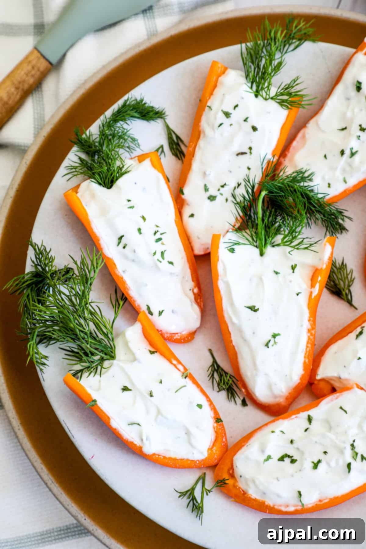 Stuffed peppers with goat cheese and dill on a plate.