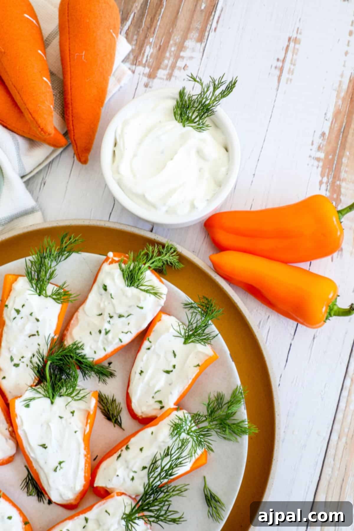A plate of carrots with goat cheese and dill on it.