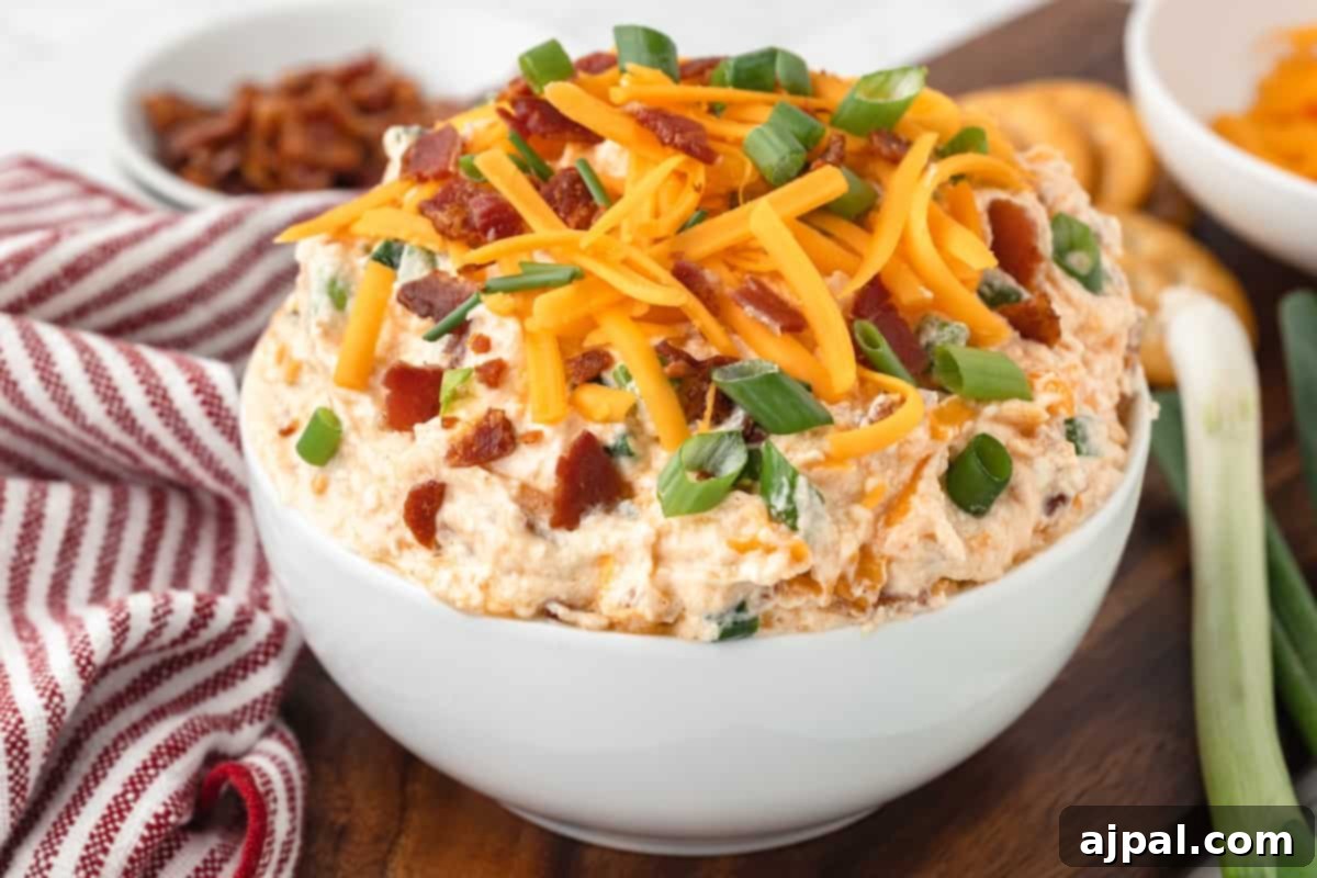 Grand Occasion Dip 3 Million Dollar Buffalo Chicken Dip served as an appetizer in a white bowl on a cutting board, garnished with fresh herbs.