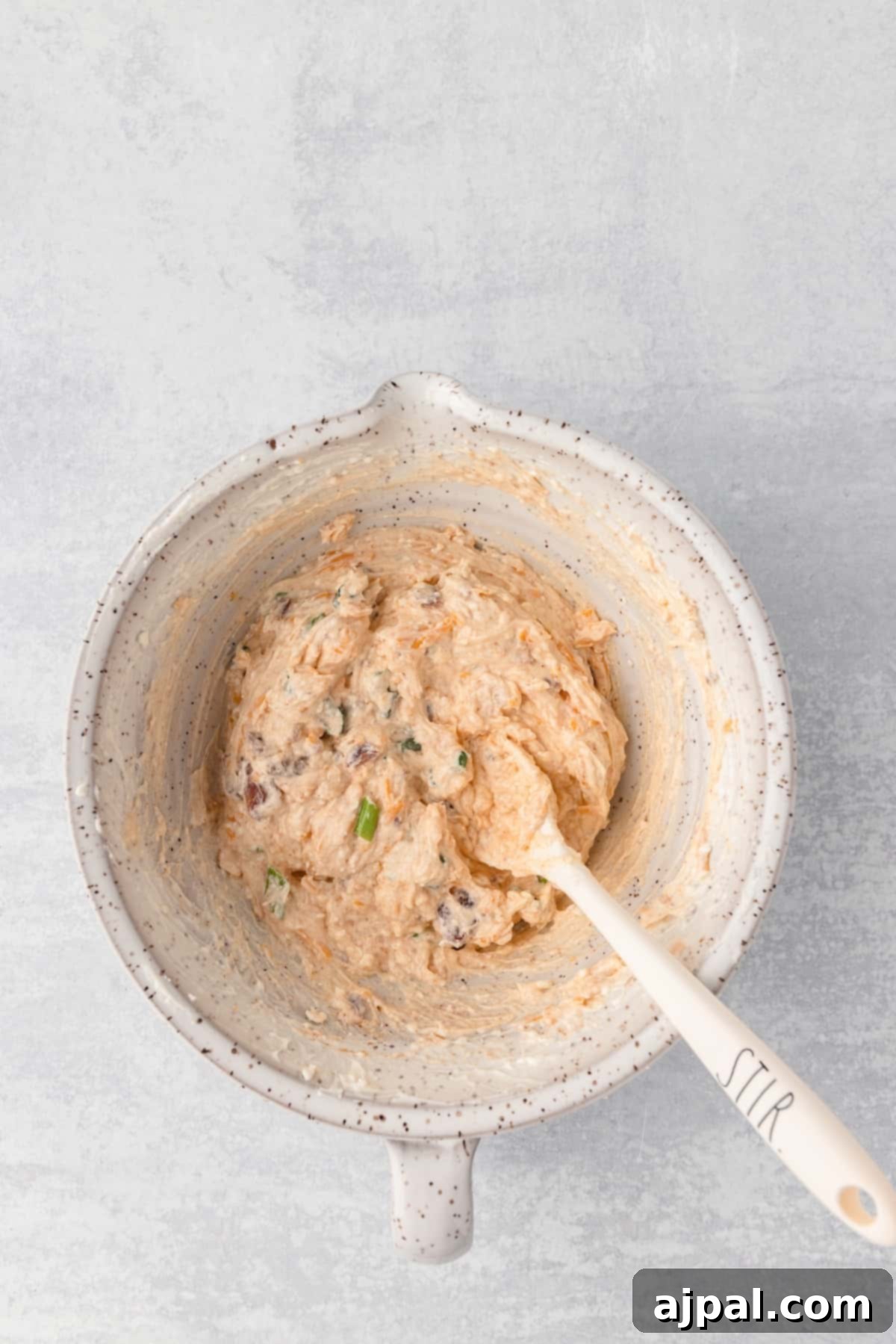 Grand Occasion Dip 9 A tempting bowl of Million Dollar Dip, complete with a spoon nestled within, ready for serving.