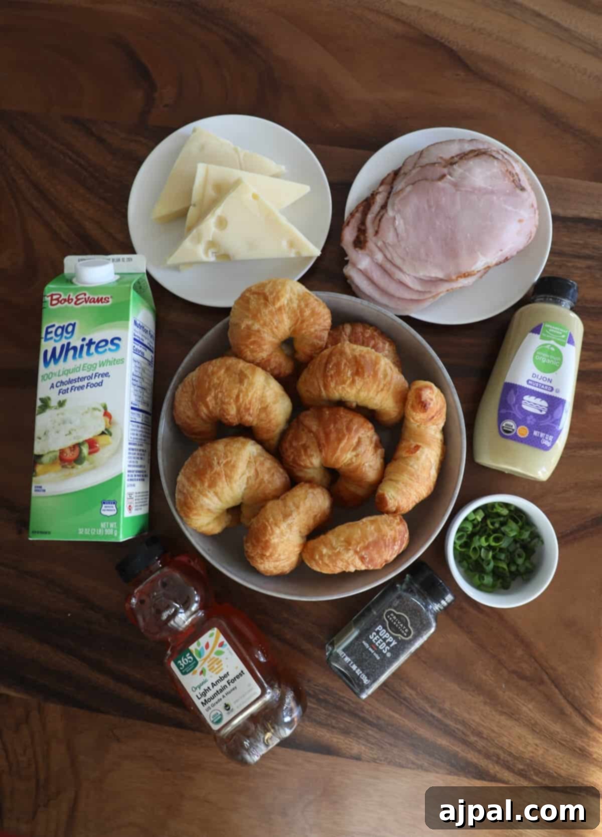 Warm Ham and Cheese Croissant Melts 8 Plate of croissants, ham, cheese, and a bottle of milk on a table, representing ingredients for preparation.