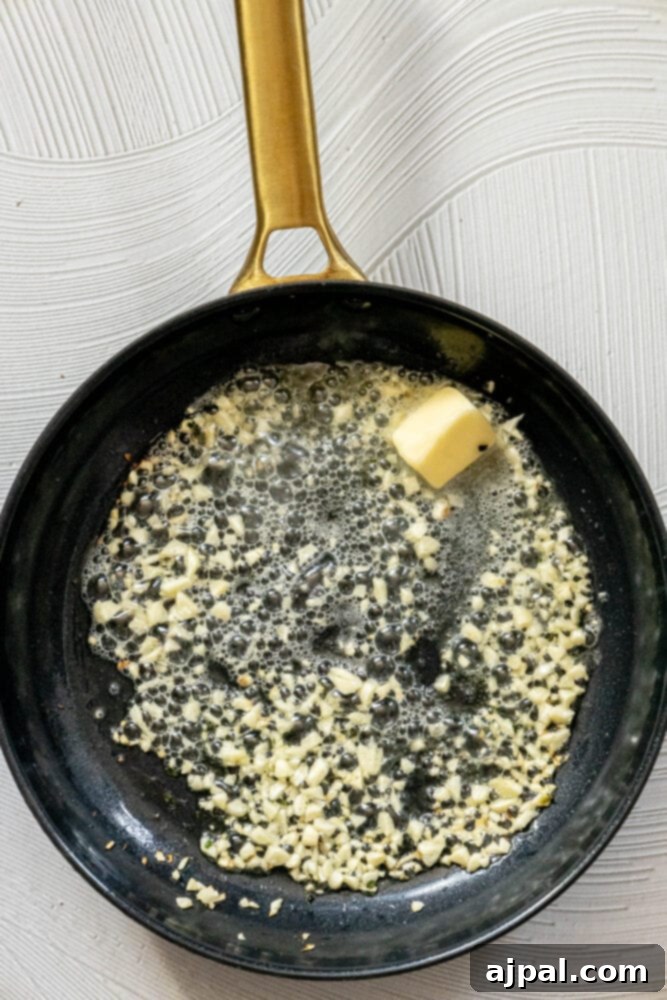 picture of garlic, olive oil, and a knob of butter in a pan 